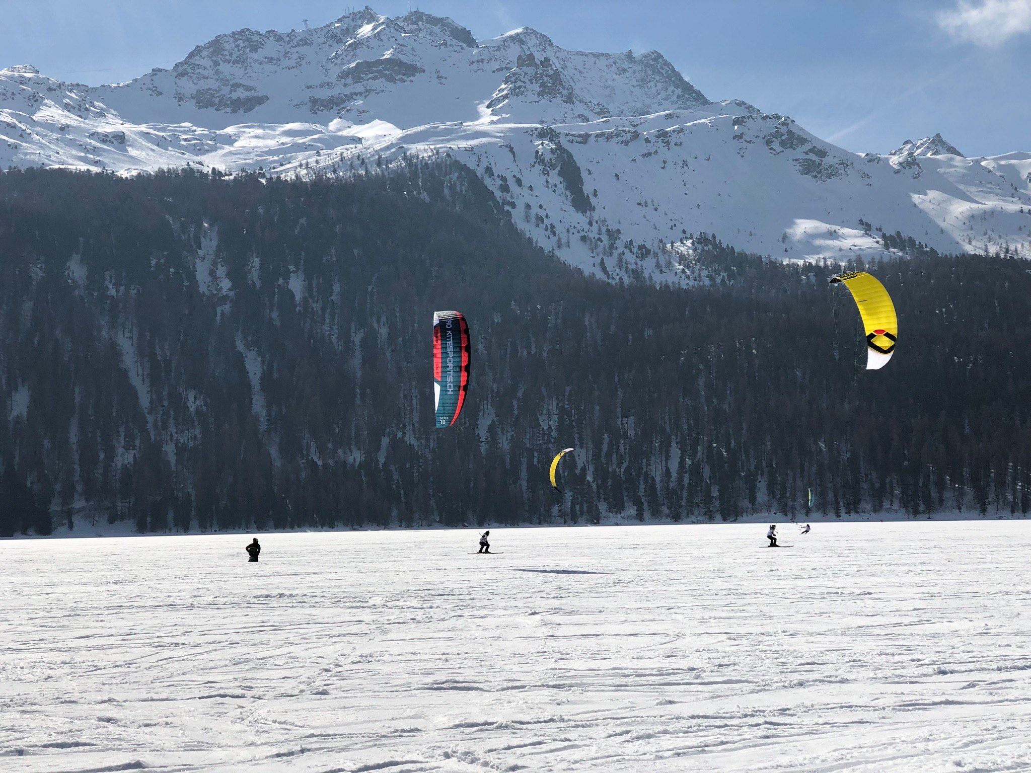 Snowkiting en el lago congelado en las montañas del Paraíso del Deporte, ideal para aventuras invernales.