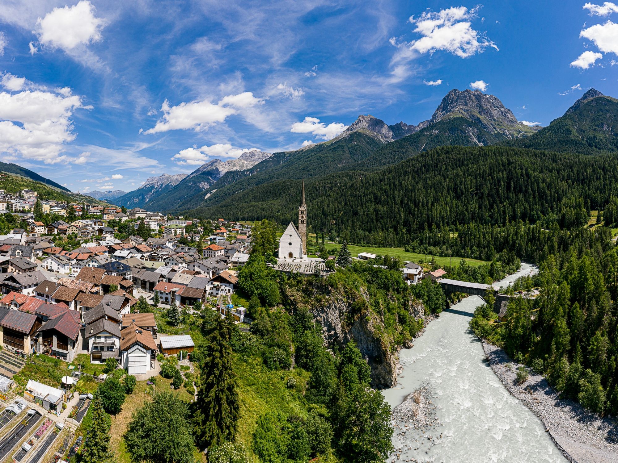 Église de Scuol avec ses environs, rivière et montagnes en été