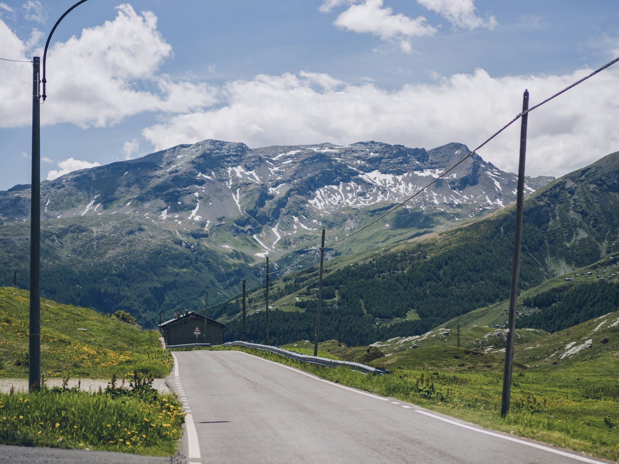 Splügen: beeindruckende Berglandschaft mit grünen Wiesen und schneebedeckten Gipfeln.