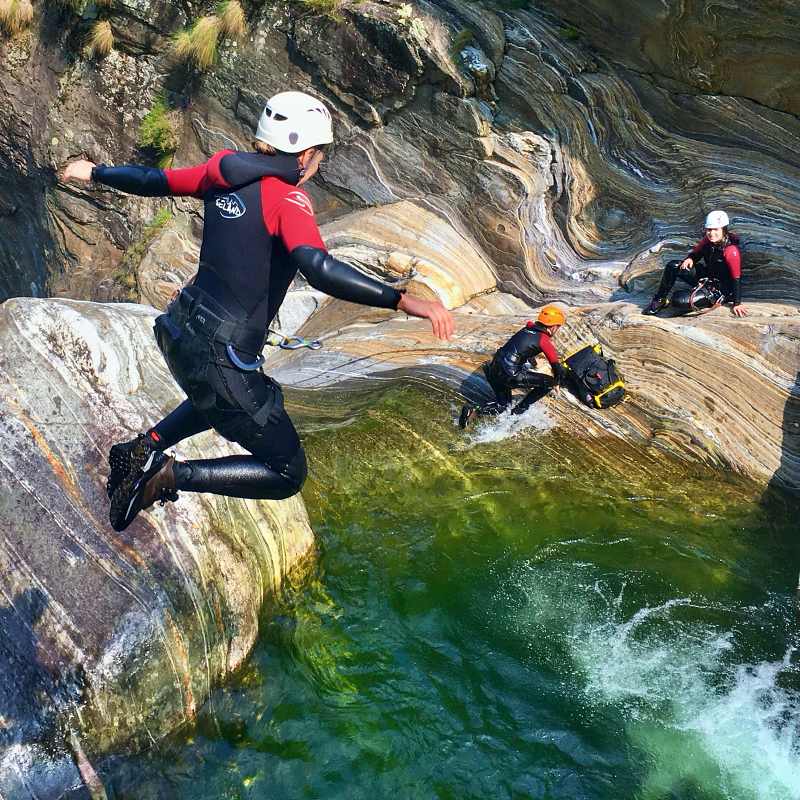Saltare nel Val Grande durante il canyoning, rocce scivolose, pozza d'acqua cristallina