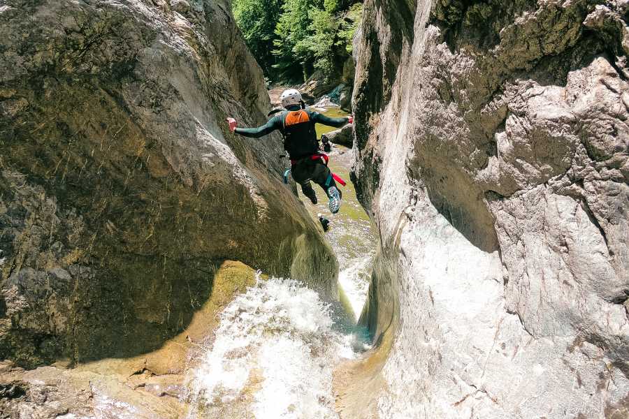 Sprung in die Schlucht Chil Schliere mit Canyoning-Aktivität in felsiger Umgebung.