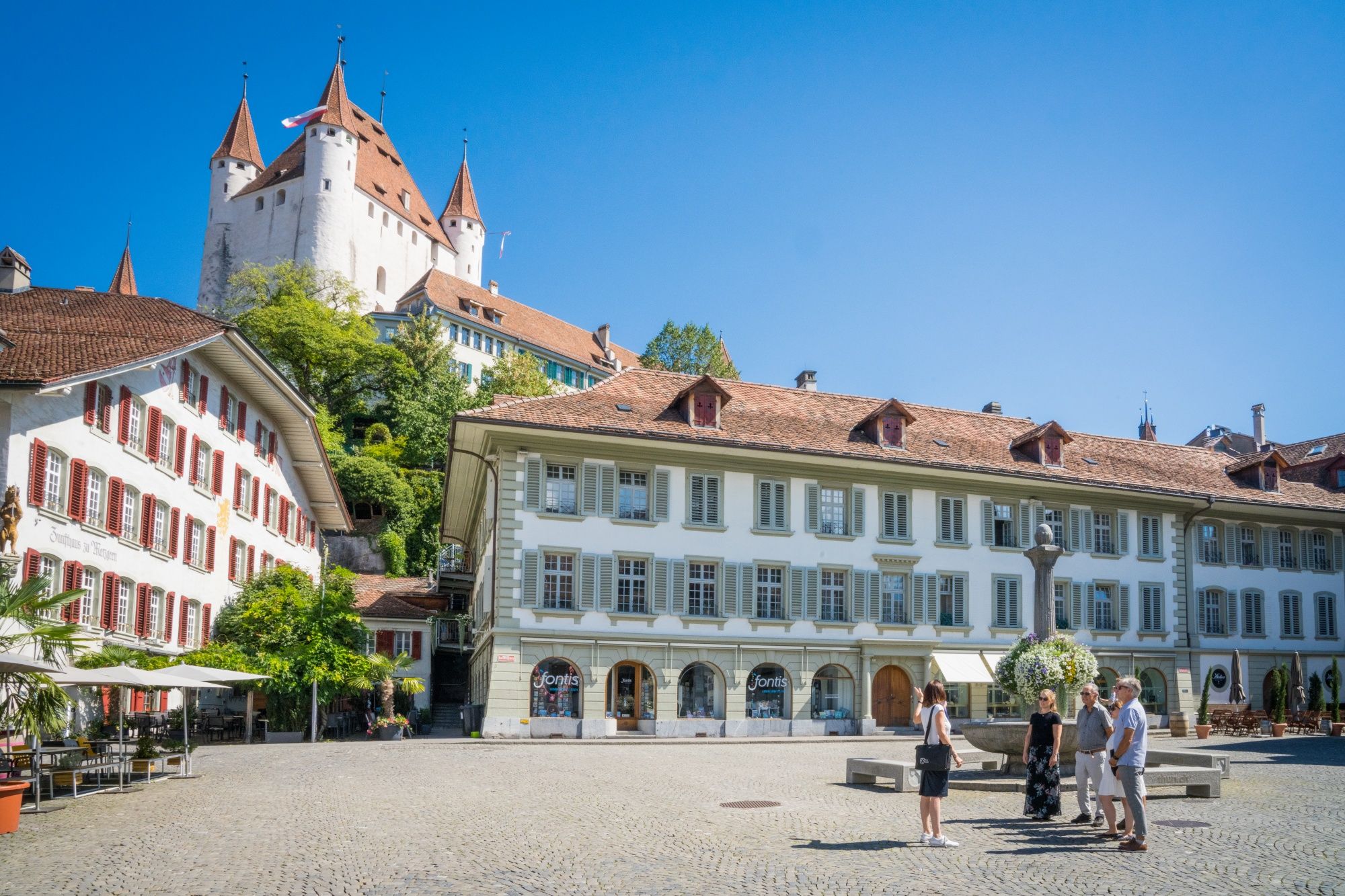 Visite guidée de Thun : Découvre des bâtiments historiques et des places charmantes dans la ville de Thun en été.