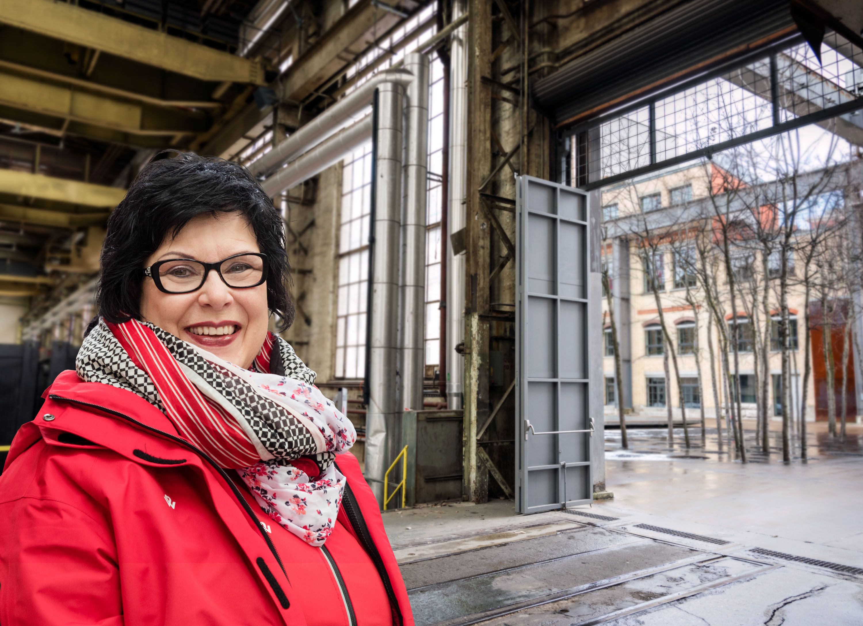 Žena v červeném saku s šálou stojí na Sulzerarealu