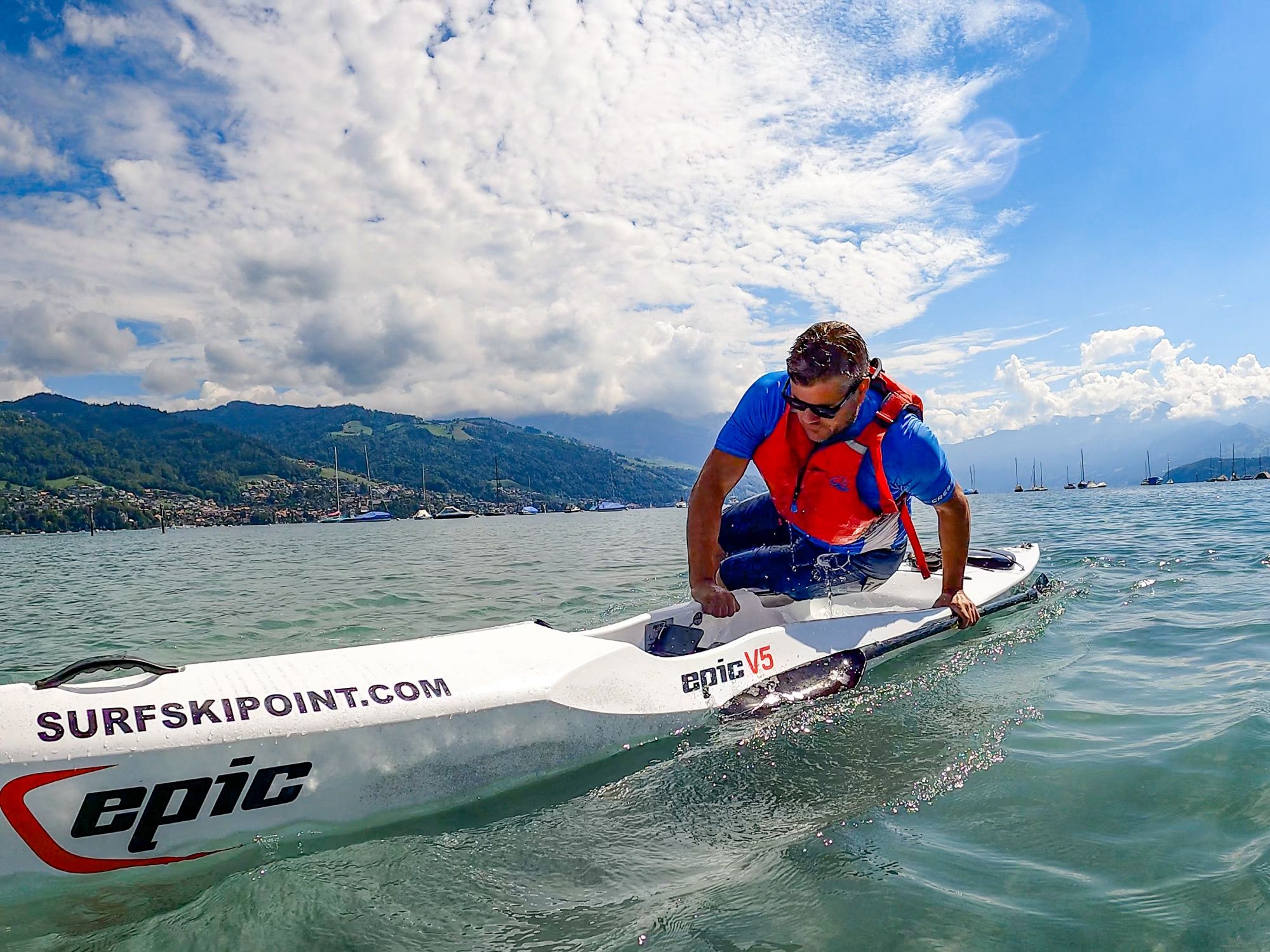 Surfskipoint: Man paddles in a kayak on the water enjoying the summer activity in the sunshine.