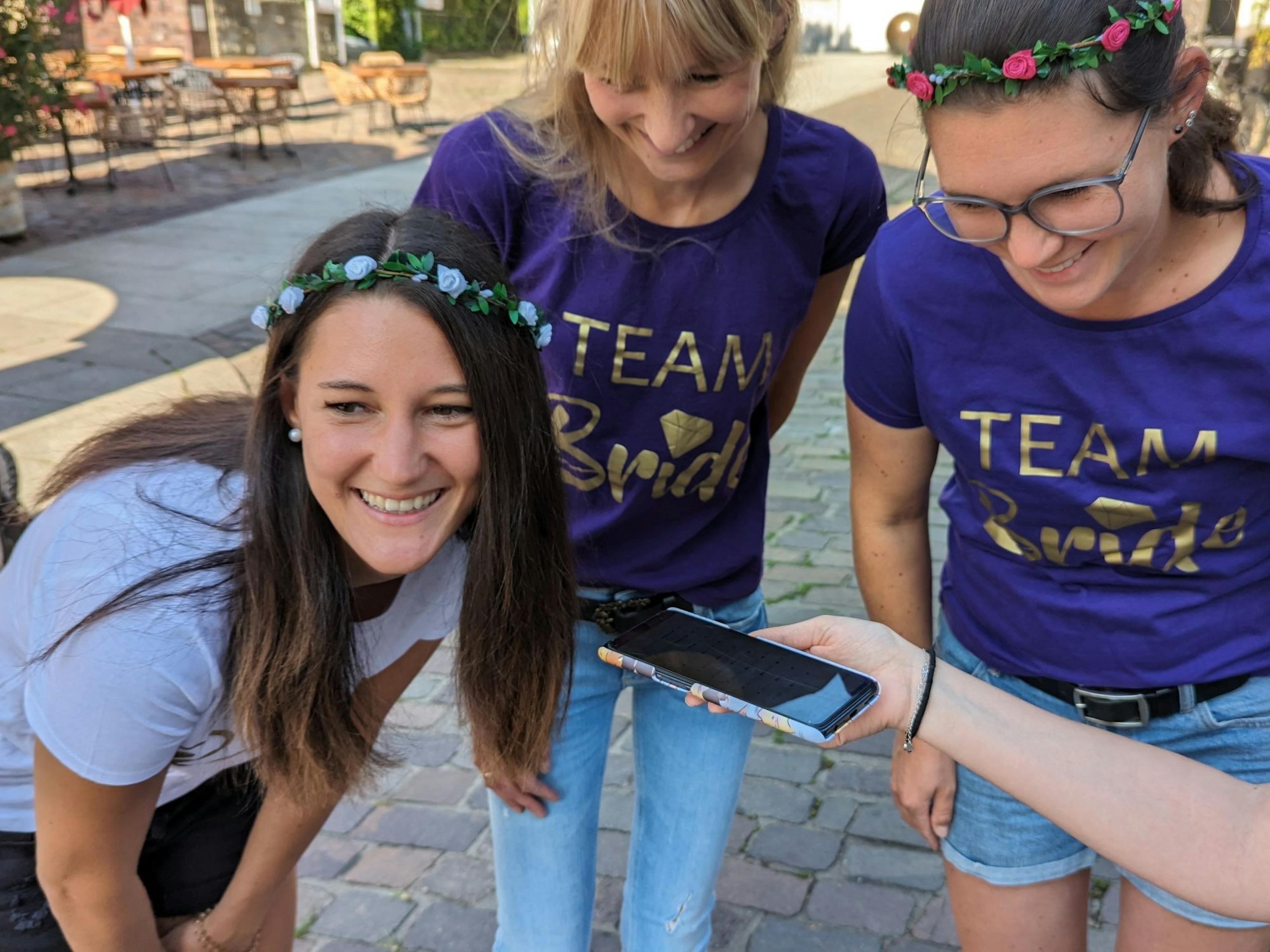 Beat the Braut: Drei Frauen lachen zusammen und genießen das Junggesellinnenabschied-Abenteuer in der Stadt.