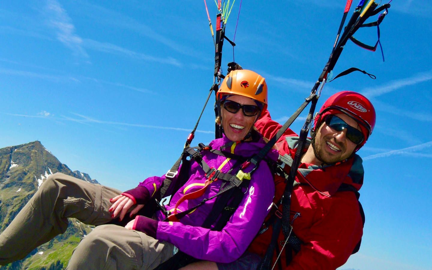 การพาราไกลด์แบบคู่กับผู้โดยสารอีกคนหนึ่งเหนือภูมิประเทศภูเขา