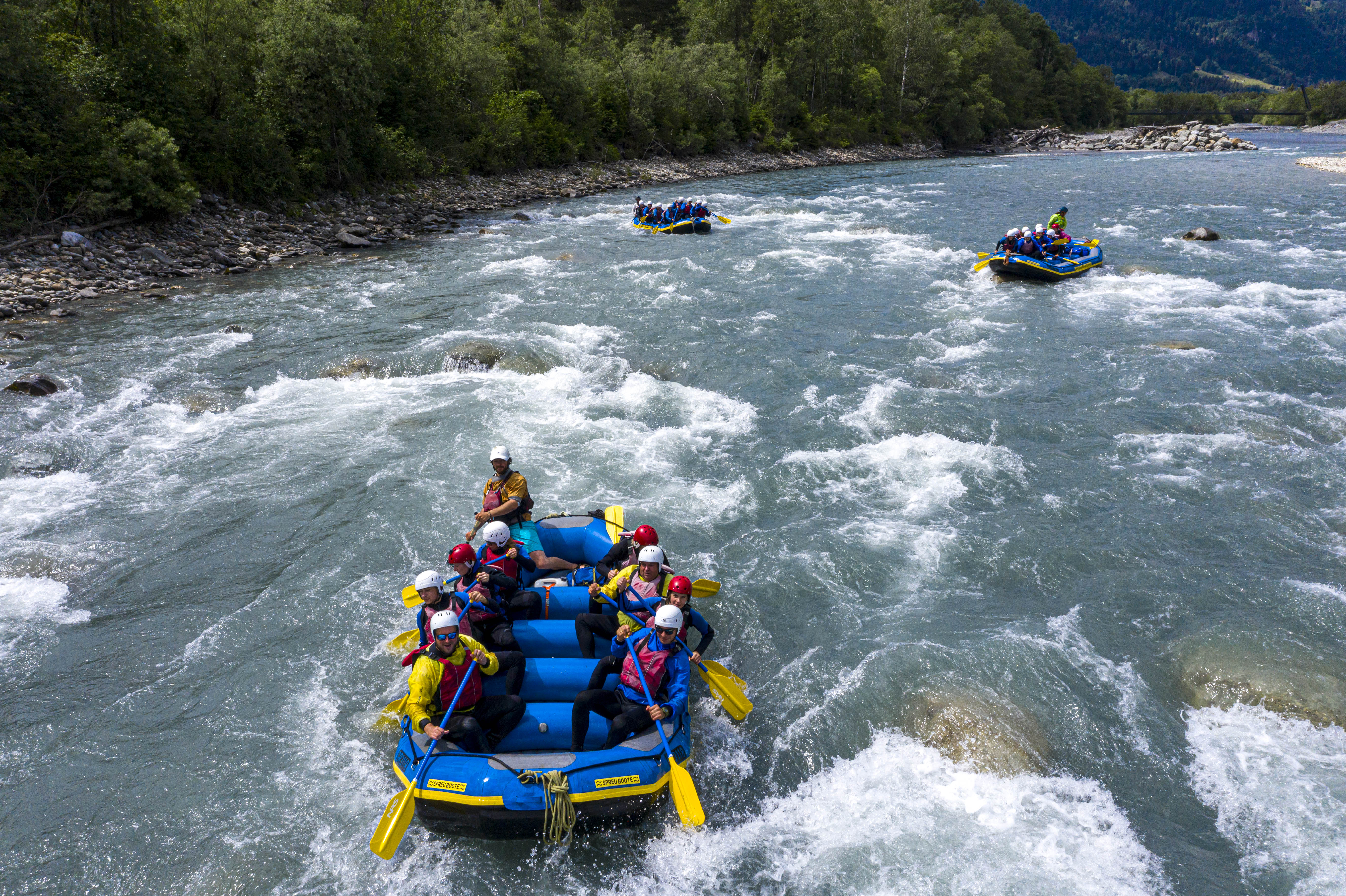 Rafting on the Vorderrhein with groups on rushing waters in sunny weather.