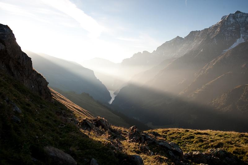 Tur wisata bartgeiert di Heidiland menampilkan pemandangan pegunungan yang mencolok dengan gunung-gunung yang jauh dan sinar matahari.