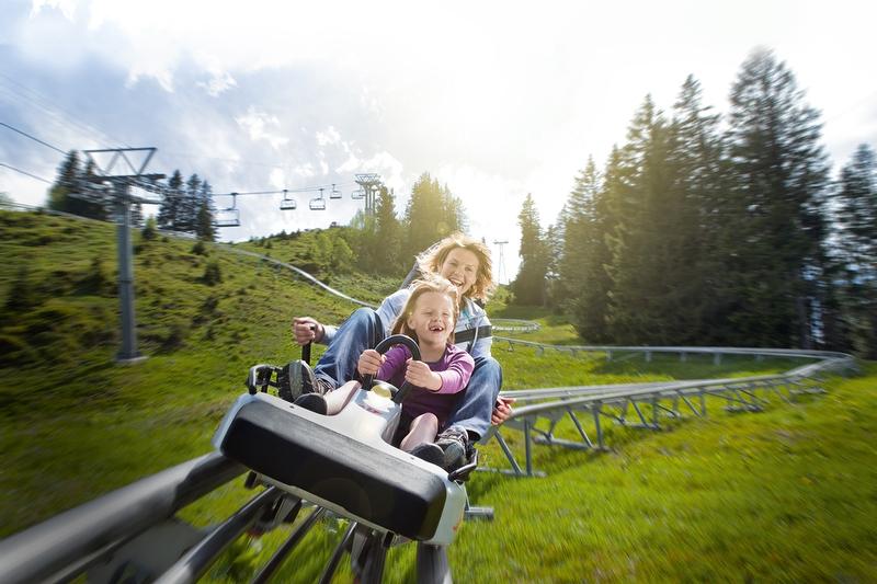 फ्लूमसेरबर्ग की आनंददायक मार्ग में सवारी वाली रॉडेलबैन, परिवार खुशी से यात्रा कर रहे हैं, गर्मियों का मौसम