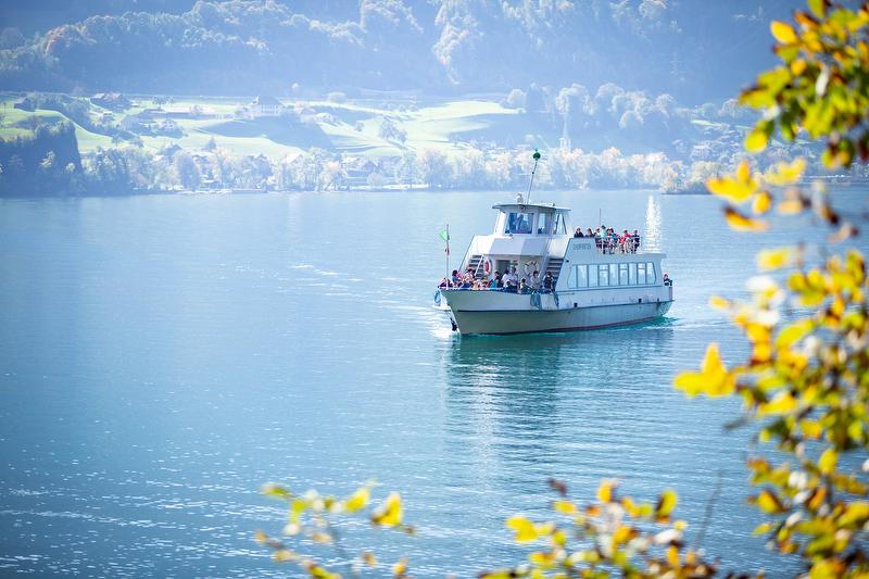 Boot op het Walensee met passagiers, mooi weer, herfstige omgeving.