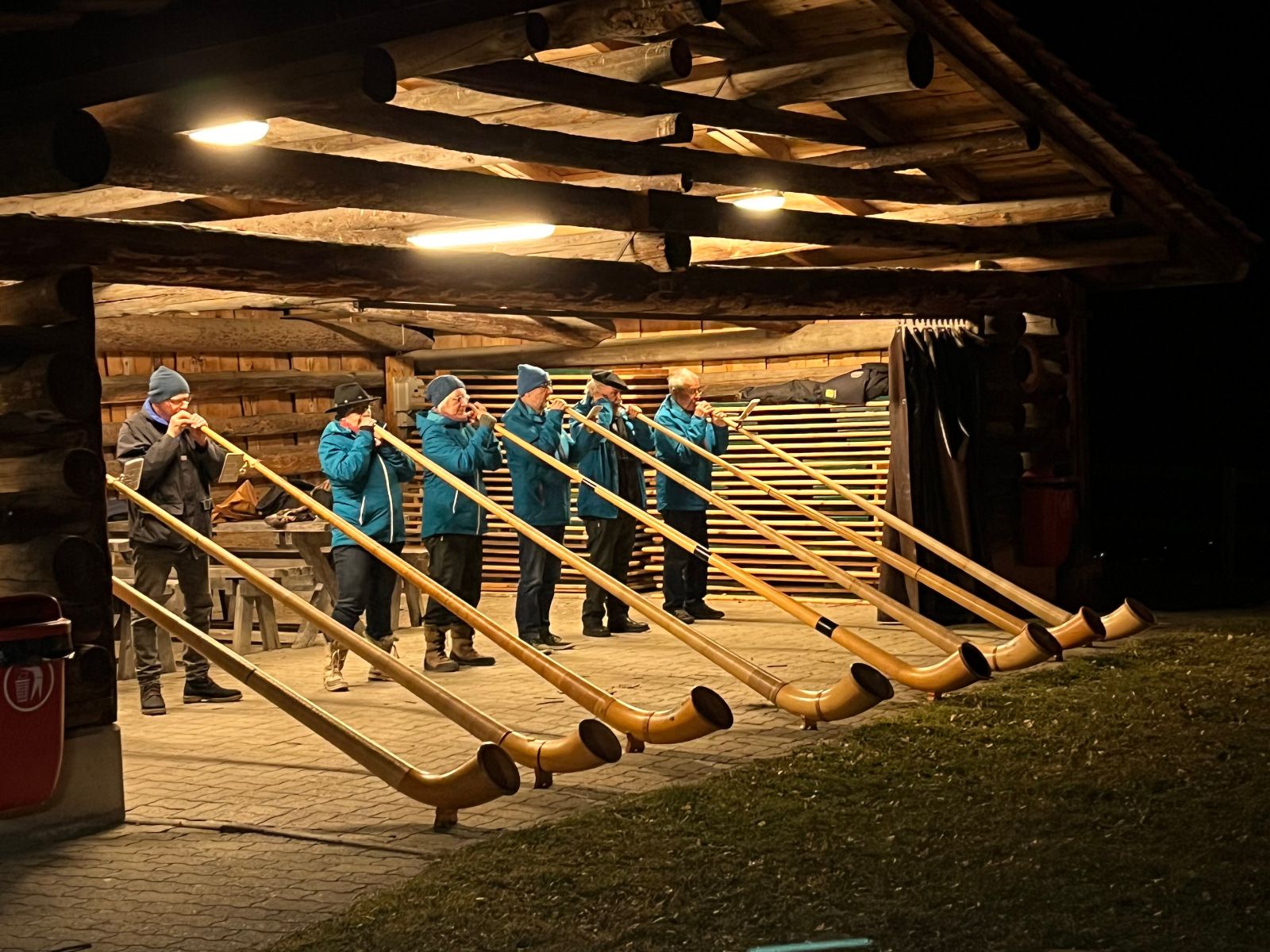 Alphorn players perform in the mountains at night. Traditional music event in the Alps.