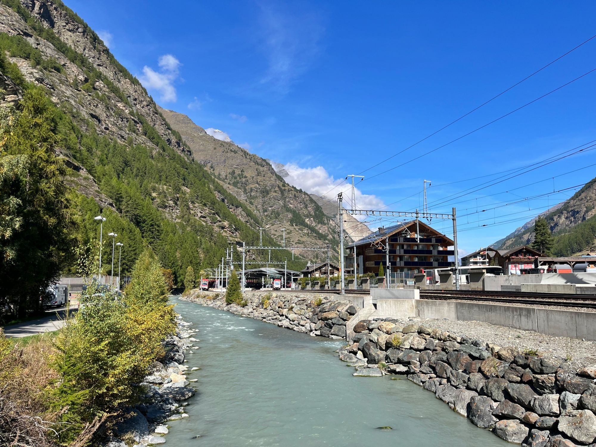 Täsch: nádherná krajina s řekou, horami a železniční tratí v Alpách. Ideální pro milovníky přírody.