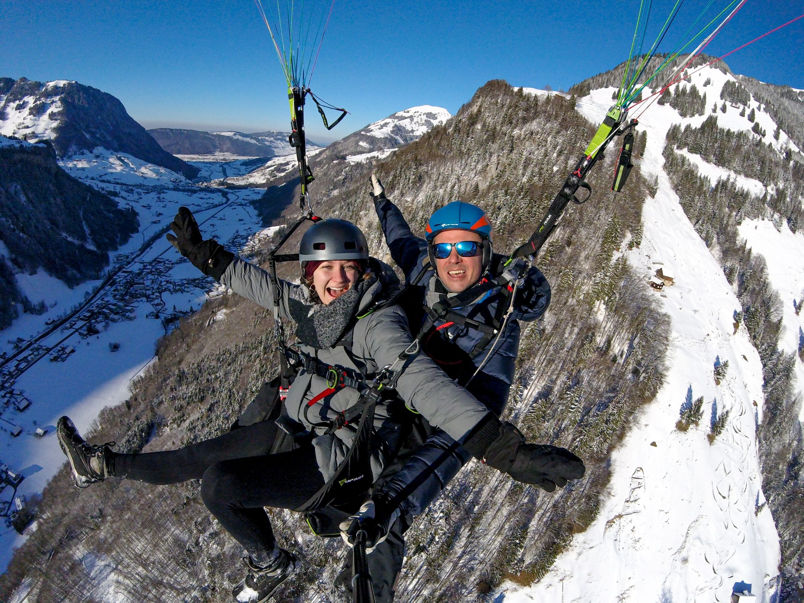 Vuelo en parapente sobre Rigi con buen tiempo, pilotos y pasajero con ropa abrigada