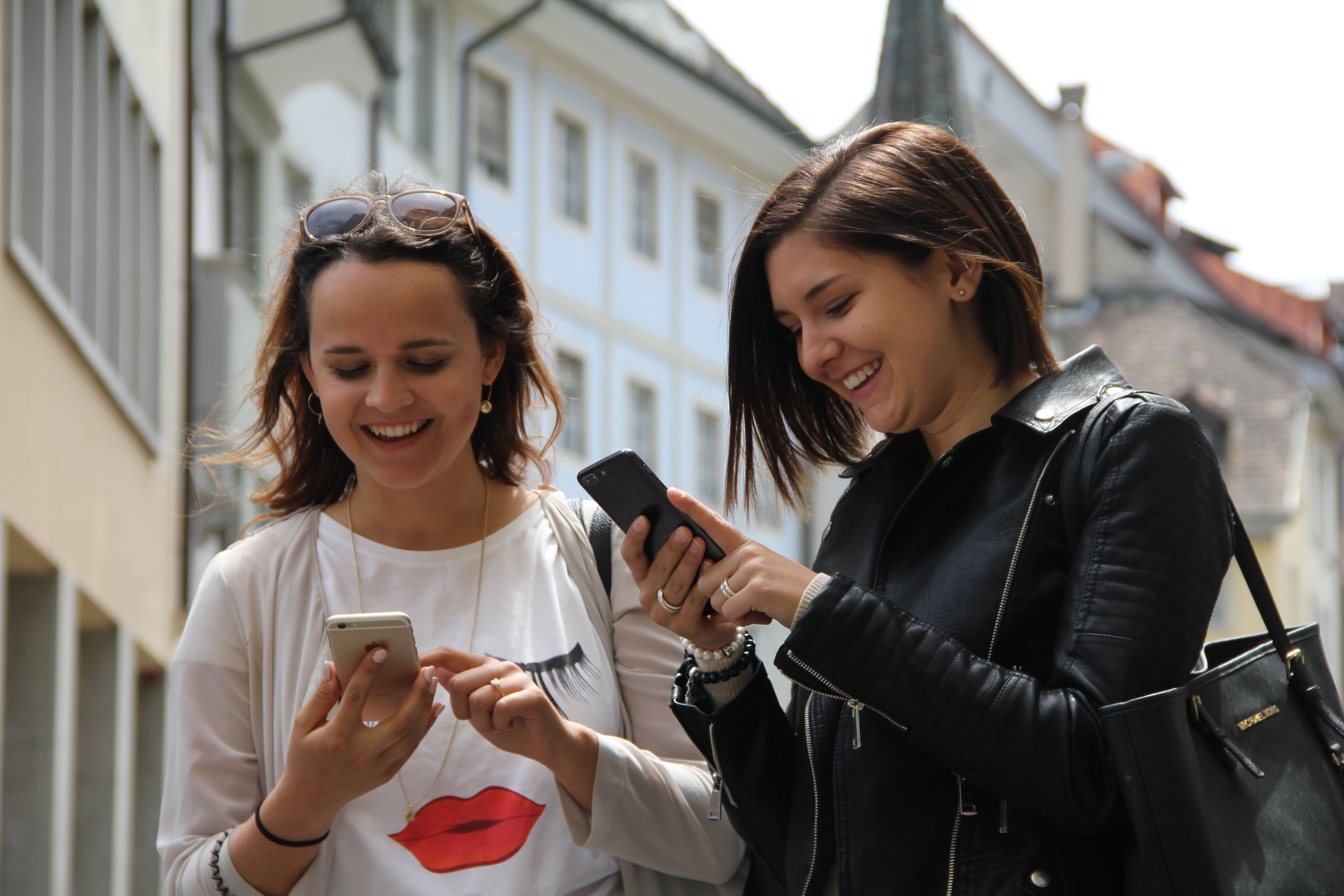 Pasukan Schnitzeljagd Schaffhausen menyelesaikan teka-teki di jalan raya, dua wanita dengan telefon pintar