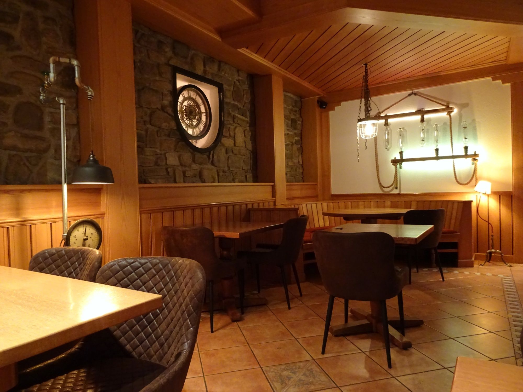 Tesla Box mit rustikalem Ambiente, gemütliche Tische und Lampen, ideal für Gruppen oder Treffen.