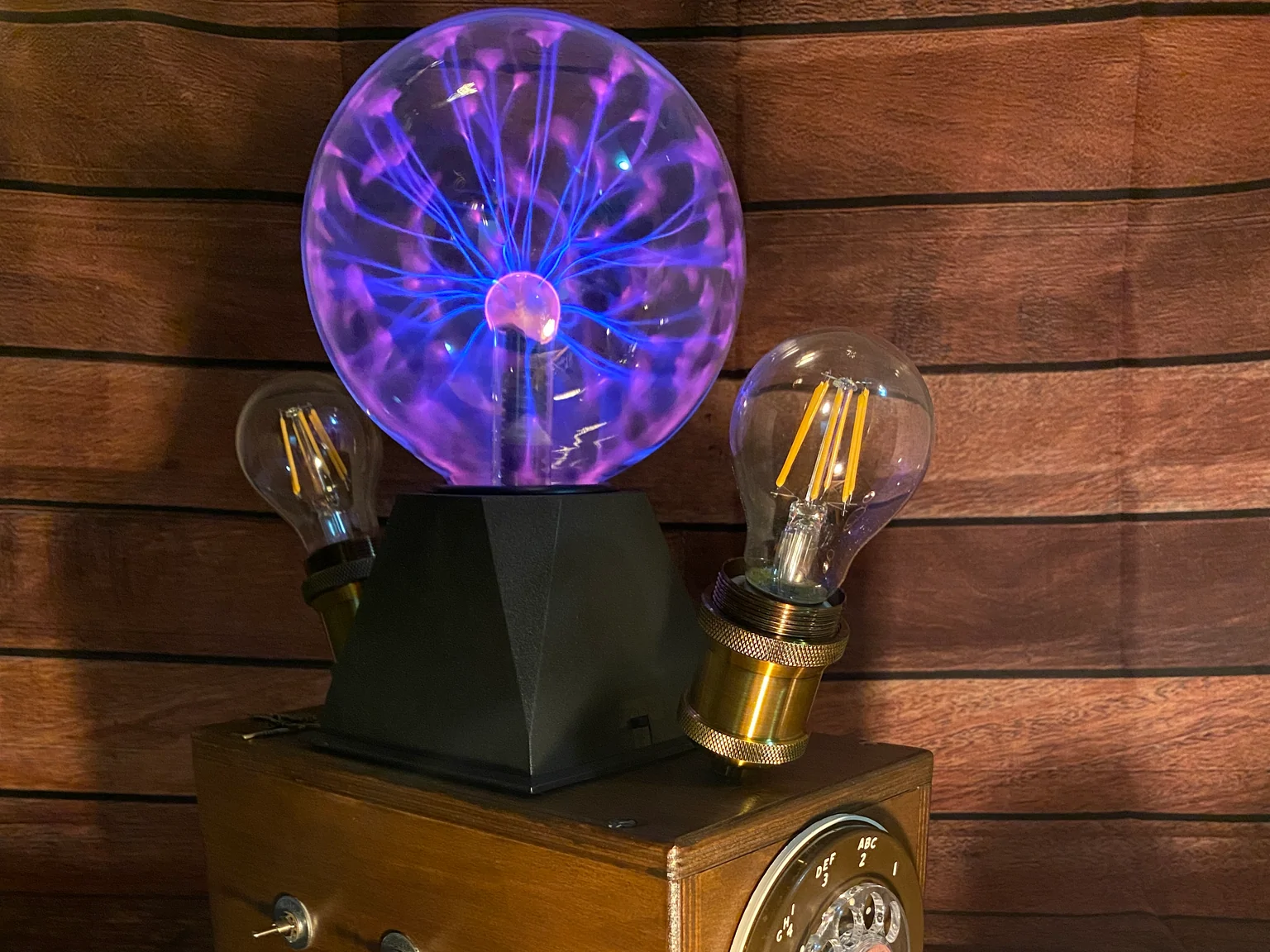 Tesla Box mit Plasma-Kugel und Glühbirnen für kreative Raumgestaltung.