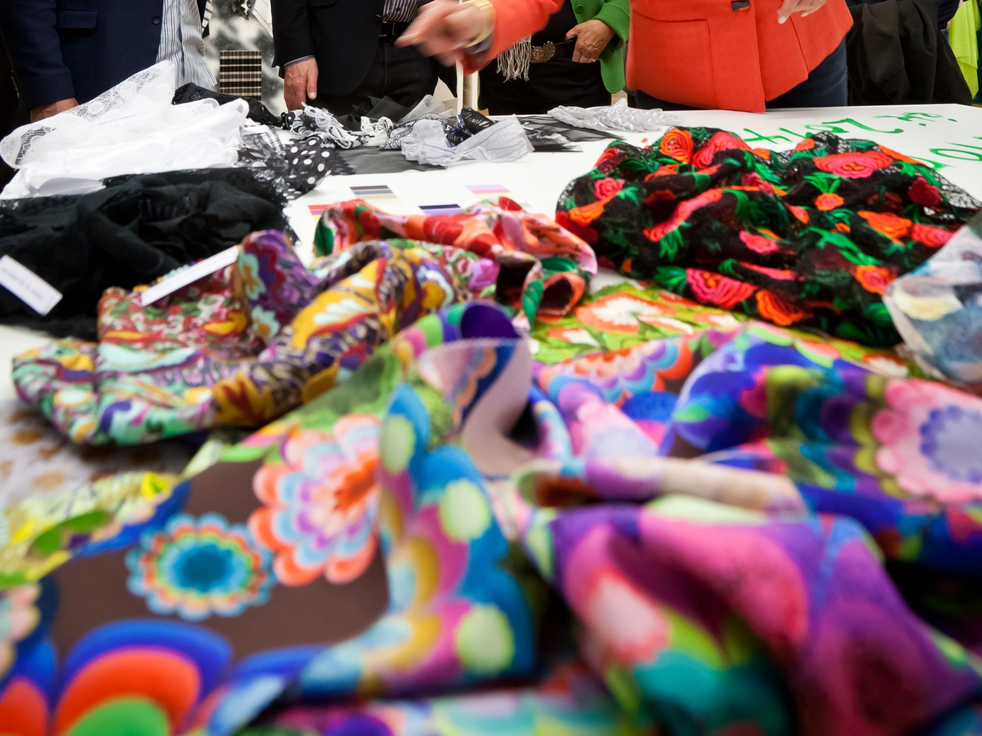 Visita guiada textil en San Galo, los participantes observan telas de colores sobre una mesa