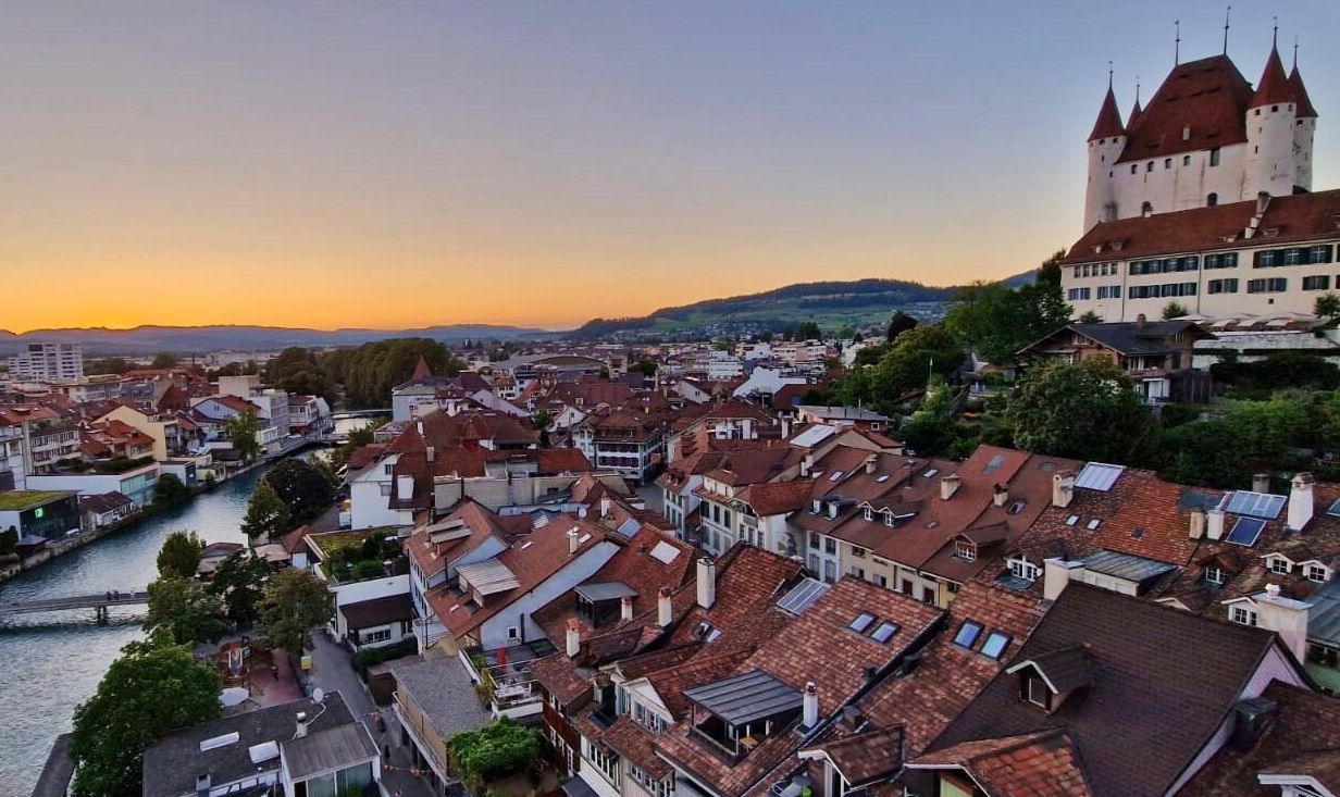 Thun: pintoresco casco antiguo con edificios históricos y suaves colinas en Suiza, ideal para explorar.