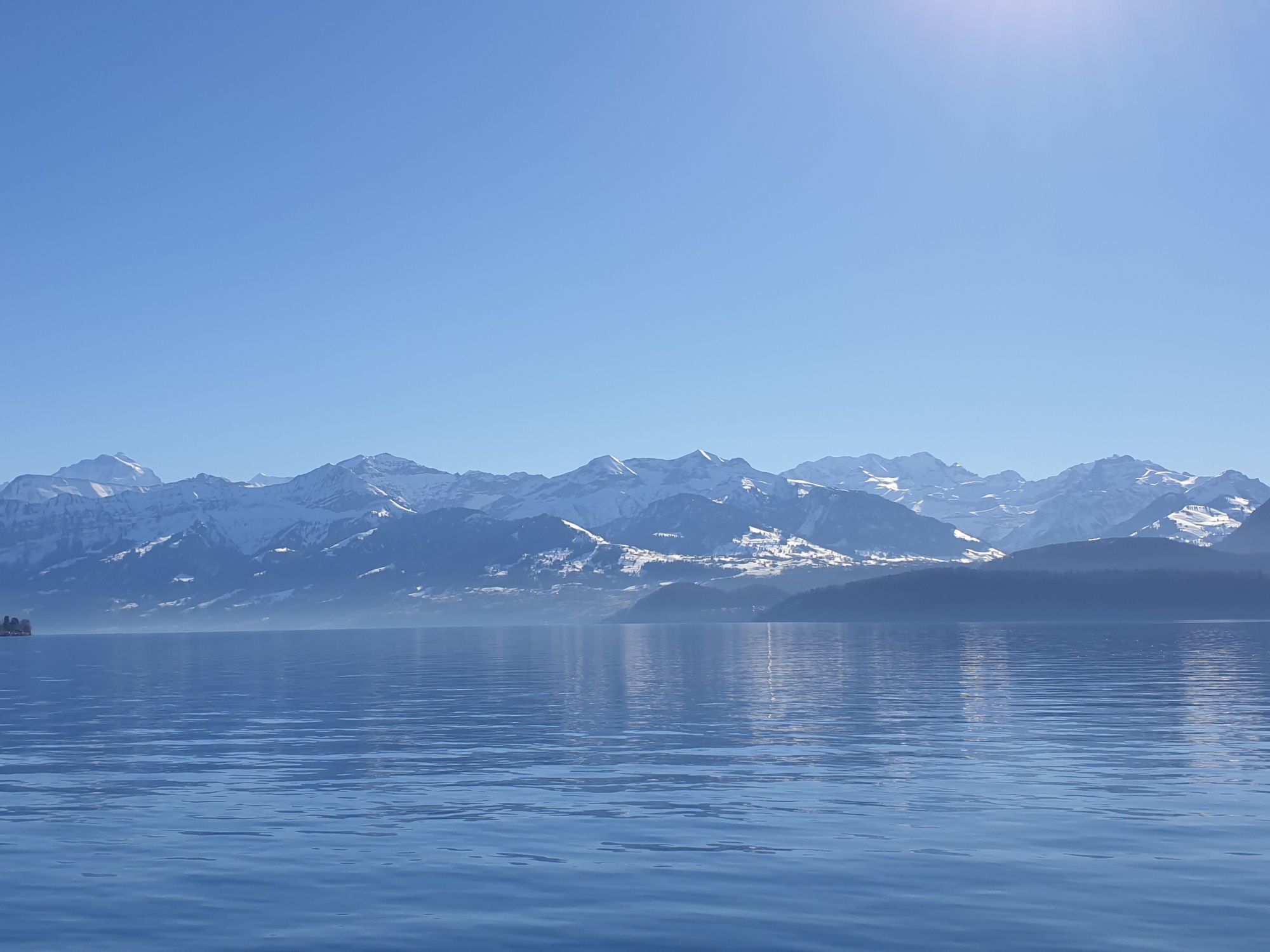 겨울의 튠 호수, 눈 덮인 산과 잔잔한 물.