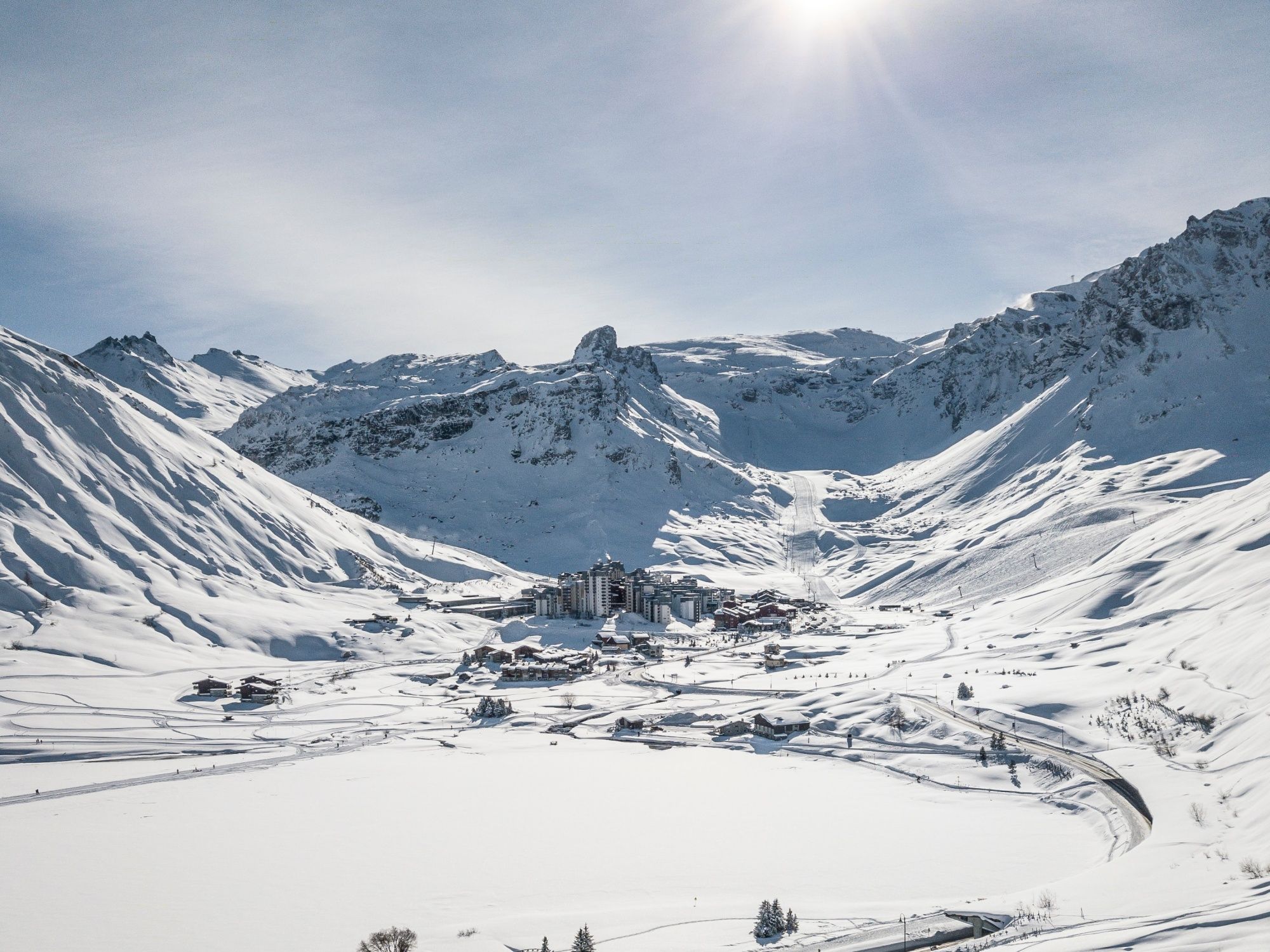 Tignes: Paisaje nevado con montañas y una pista de esquí en invierno.