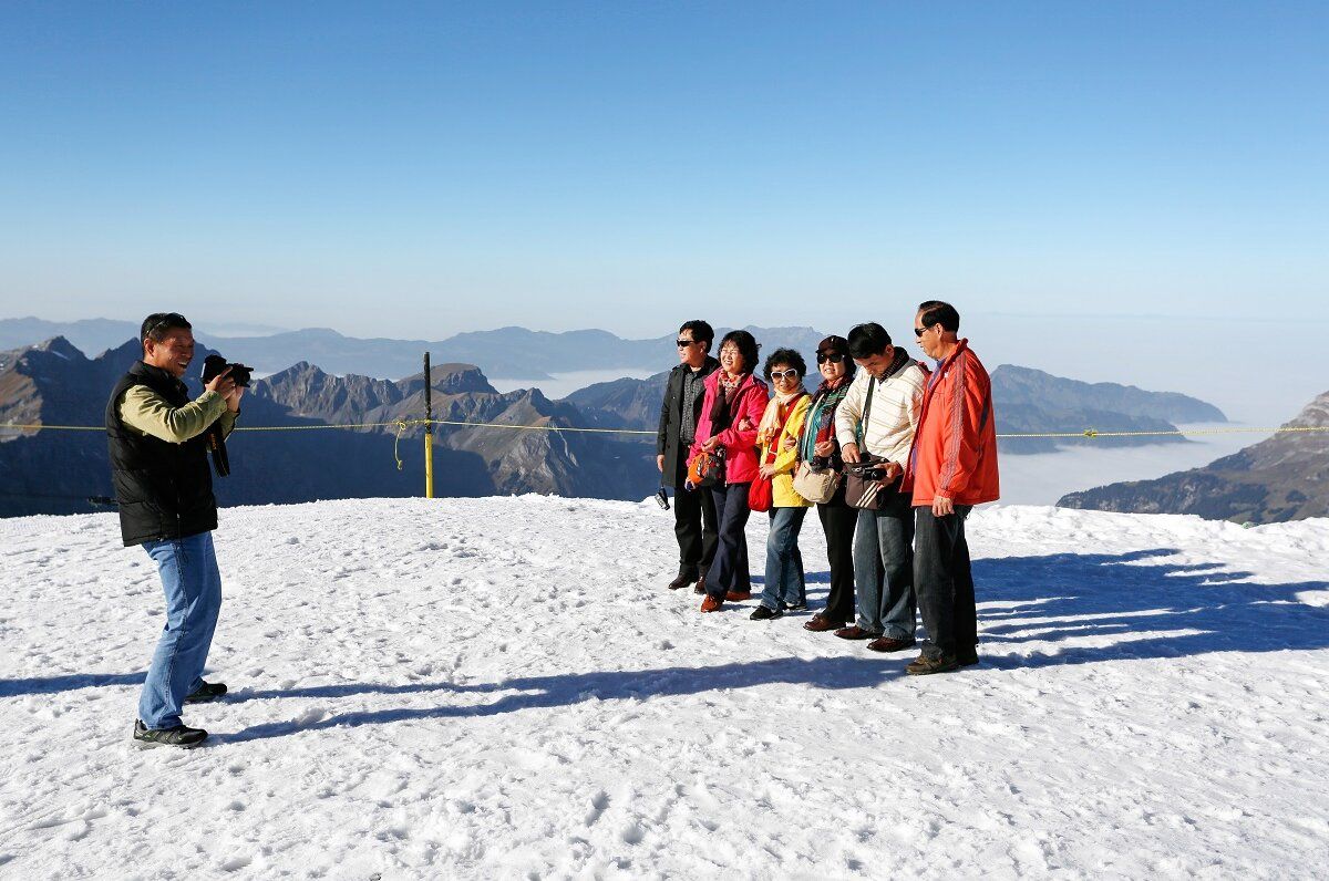 Titlis Tagesausflug mit Besuchern auf Schnee, Fotograf macht Aufnahme der Gruppe