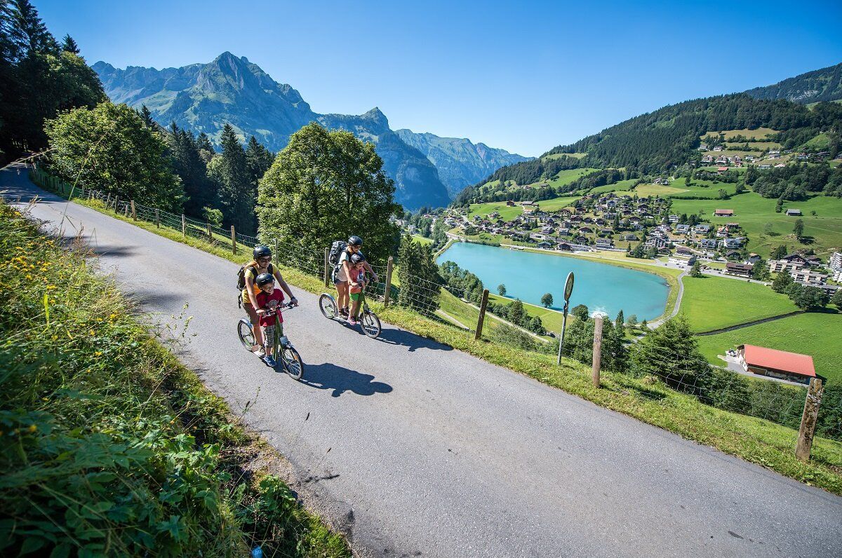 トロッティバイクエンゲルベルグ。2人が美しい緑の道をトロッティバイクで走っています。