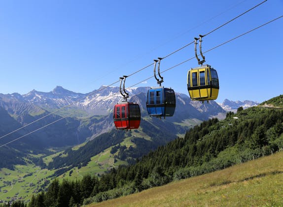 Tschentenalp Gondelbahn mit roten und blauen Kabinen vor Bergpanorama.