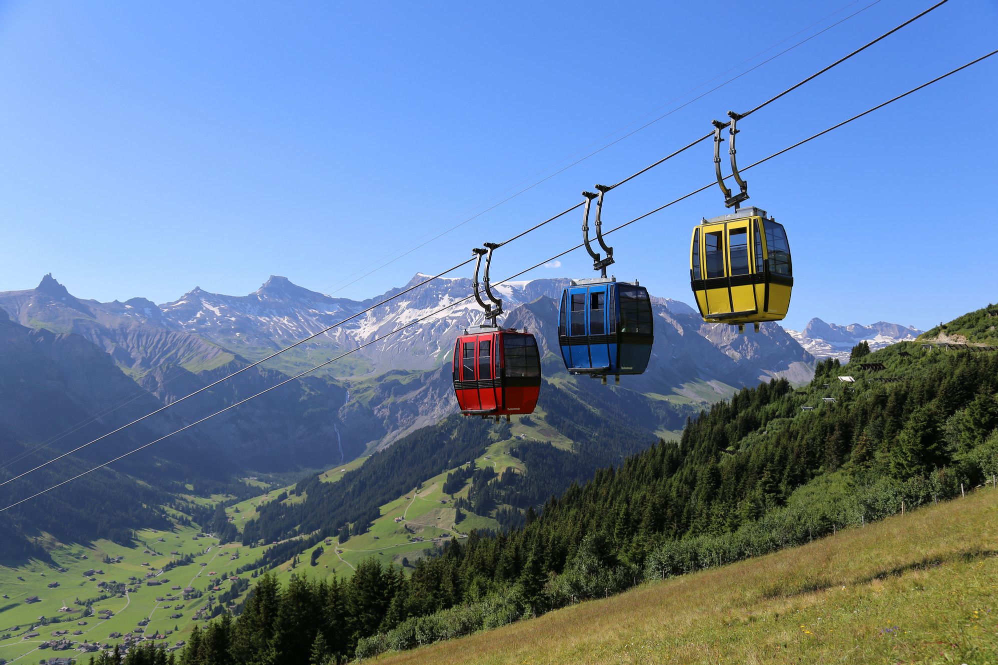 Tschentenalp Cable Car with three cabins in front of mountain landscape