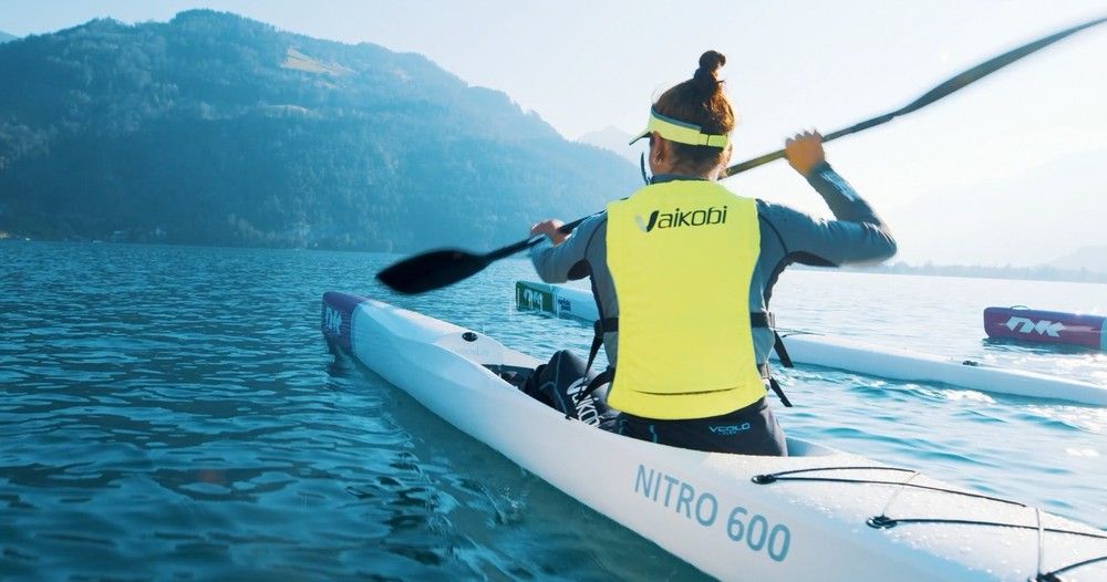Půjčovna kajaku, paddleboarding na klidné vodě, jasná viditelnost, hory v pozadí