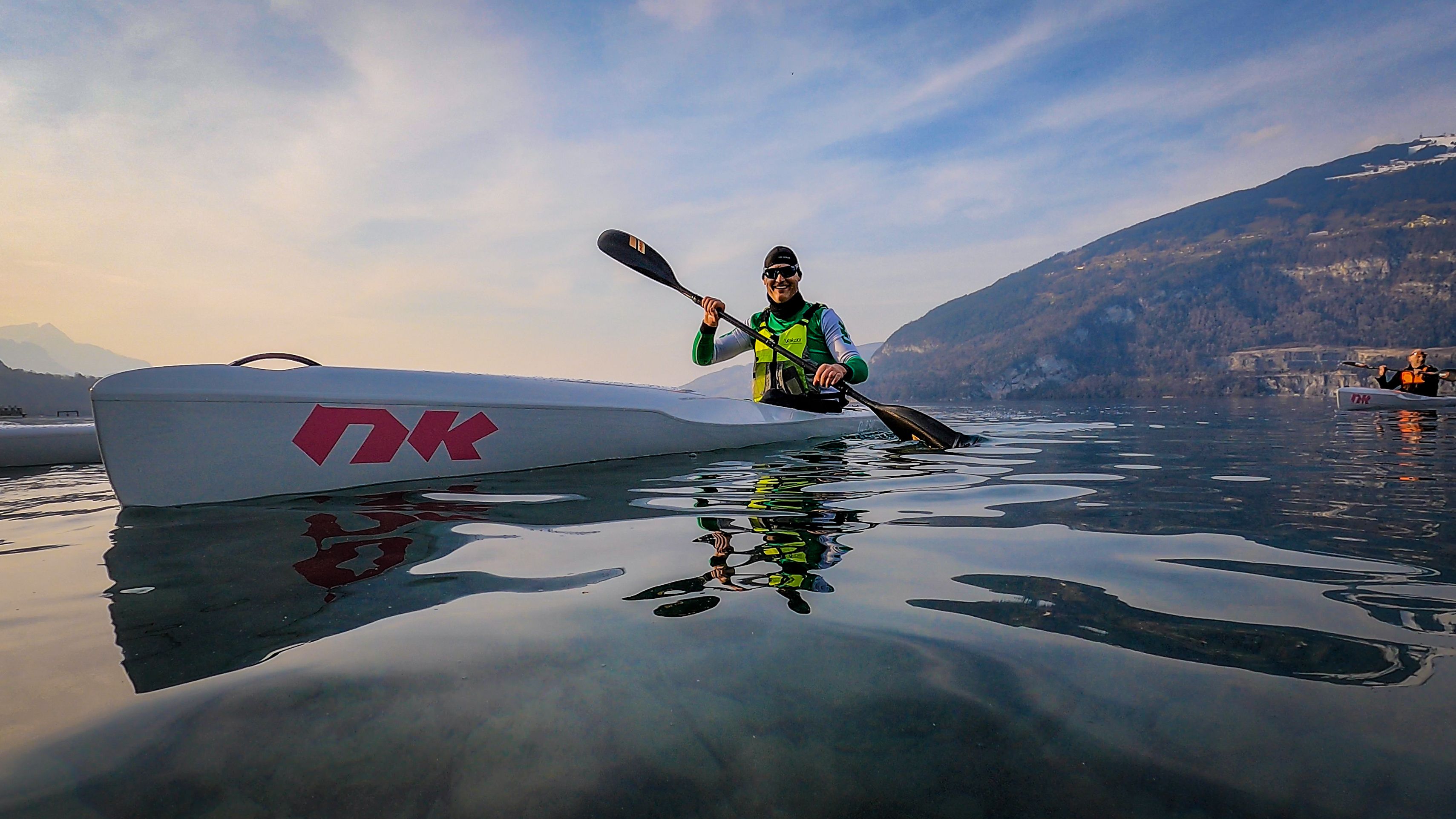 보덴 호수에서 카약 대여, 잔잔한 물에서 패들러, 배경 속 산들.