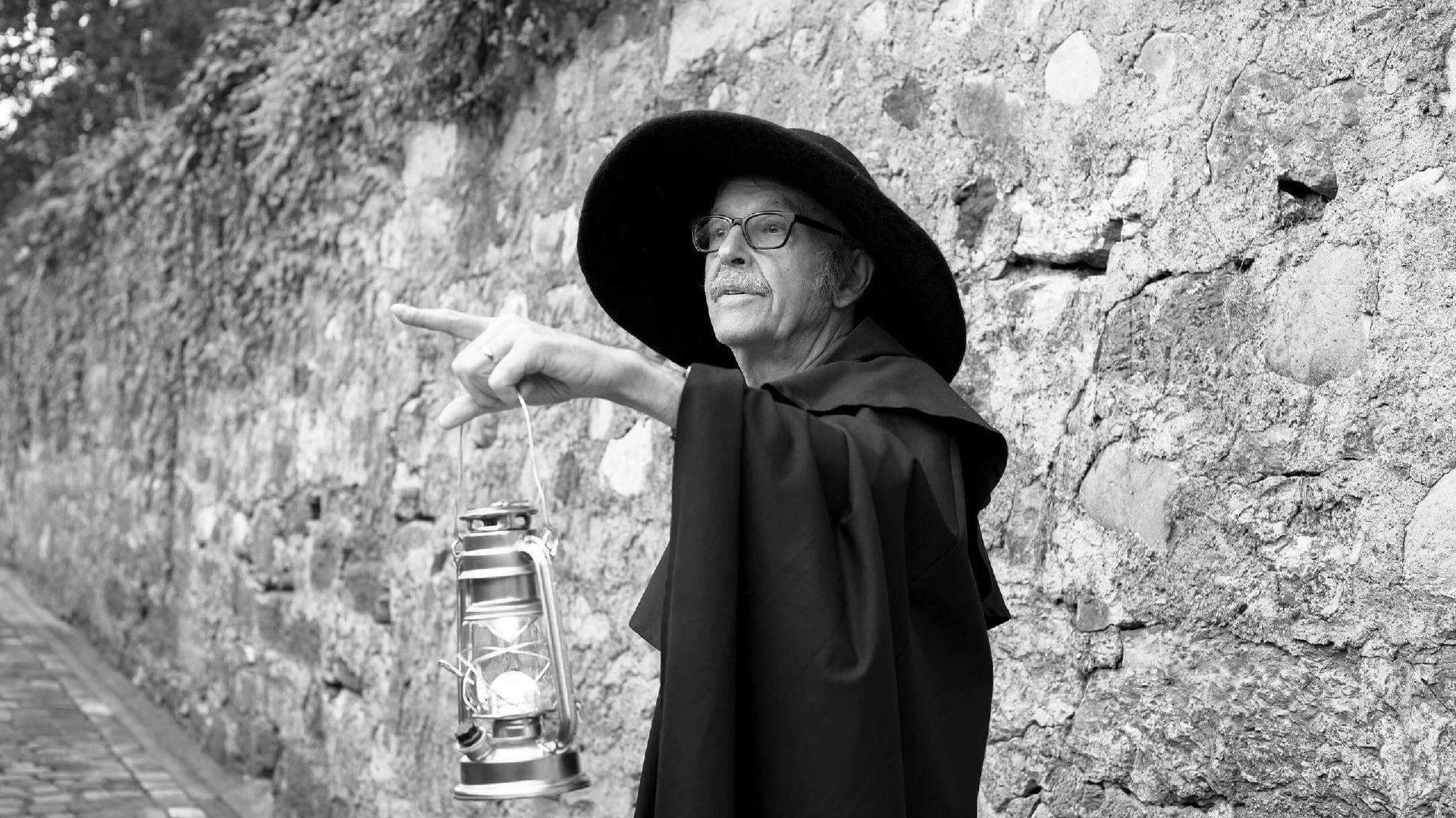 Gids met lantaarn wijst naar historische muur in Thun