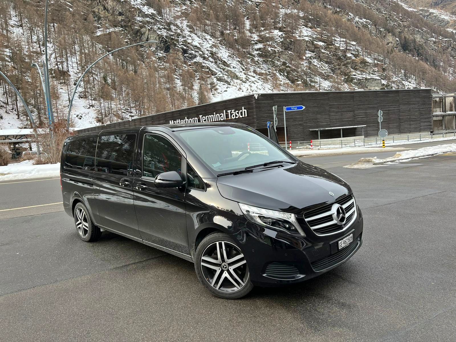 Transfert de Genève à Zermatt en van noir, en arrière-plan le terminal à Täsch.