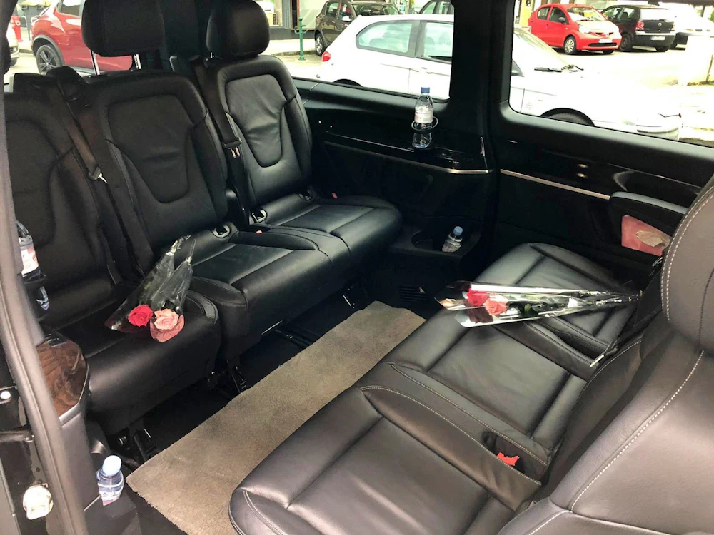 Transfer von Genf nach Lausanne in einem schwarzen Fahrzeug mit LederInnenausstattung und Rosen