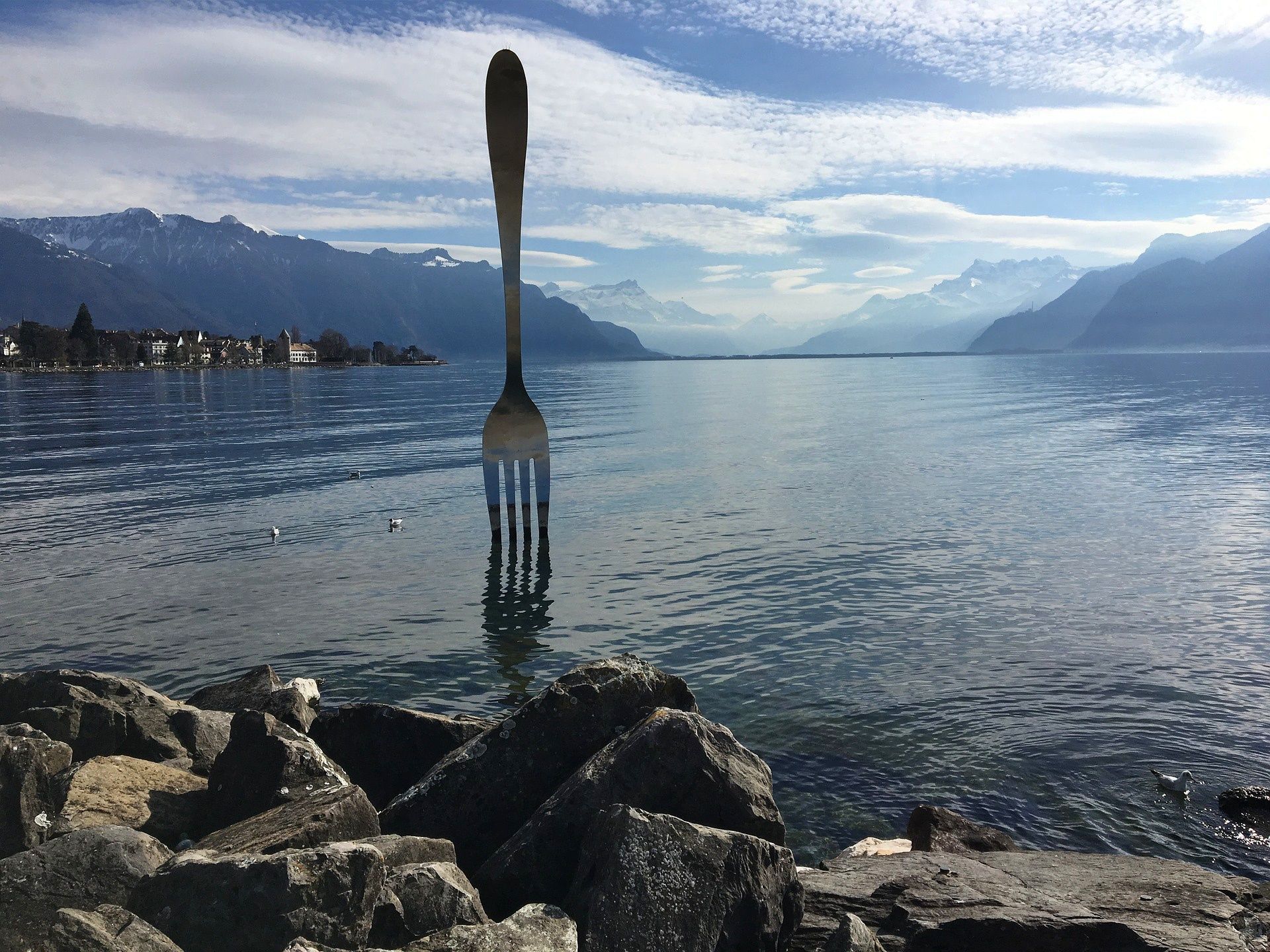 Vevey: ช้อนยาวที่น่าประทับใจริมทะเลสาบเจนีวาพร้อมภูเขาและศิลปะในพื้นหลัง.