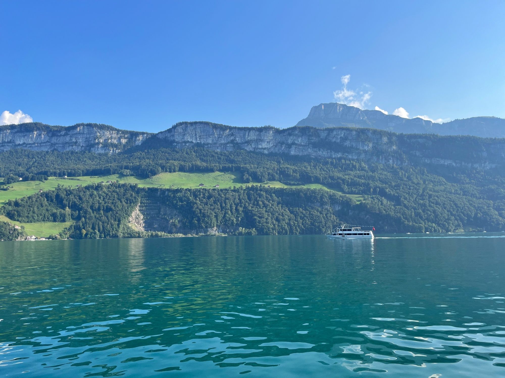 Vierwaldstätternsjön med pittoresk bergsbygd och båt, perfekt för friluftsaktiviteter.