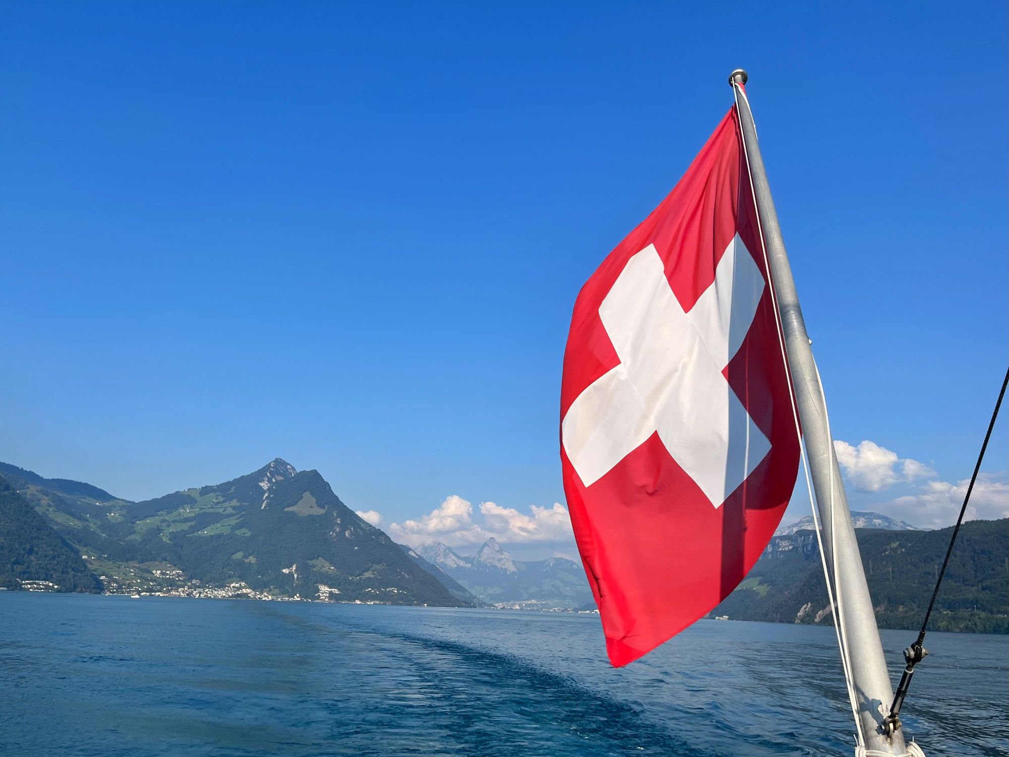 Vierwaldstättersee med blick på bergen och schweizisk flagga, ren natur på sommaren.