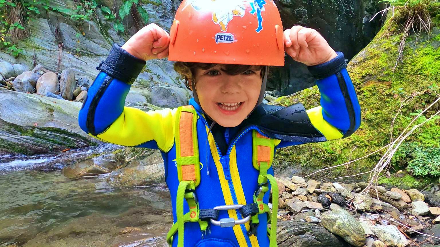 เด็กกำลังเล่น Canyoning ใส่หมวกกันน็อกและชุดนีโอพรีนในหุบเขา Vira.