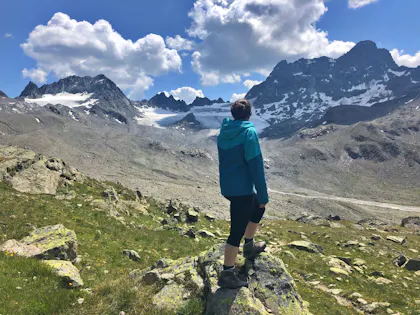 Wandern in Graubünden: Seraina genießt die Berglandschaft und frische Luft in den Alpen.