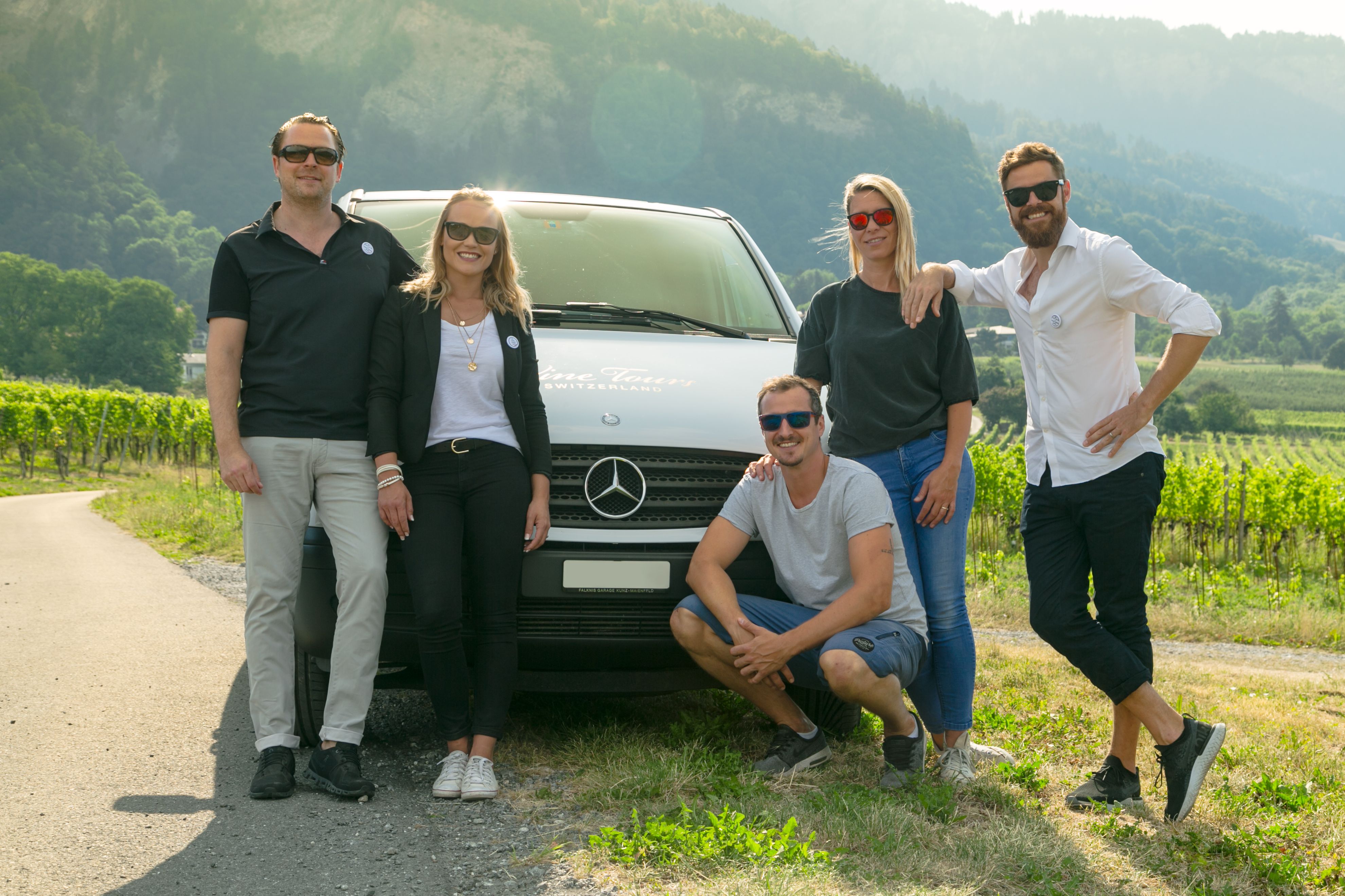 Tour de vinho em grupo privado está na frente de uma van Mercedes na região vinícola.