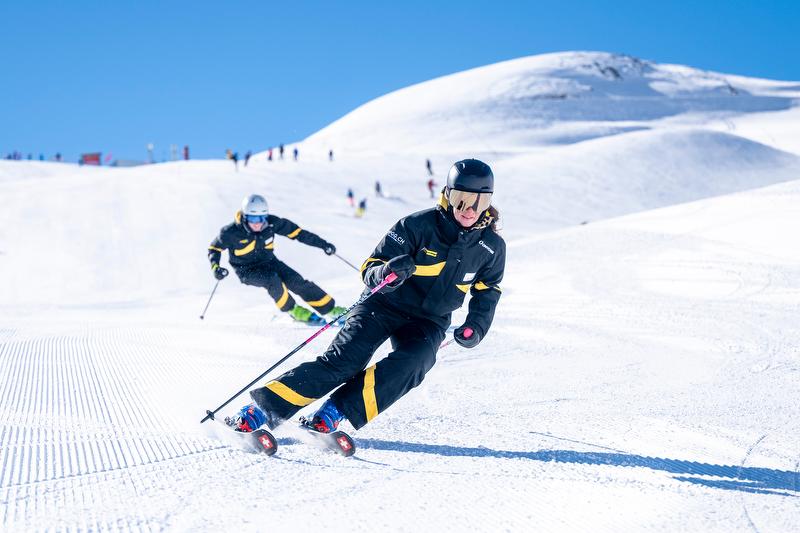 आदर्श परिस्थितियों में बीते हुए में हिमपर्वत की स्लोप पर फिर से सिखना, विशेषज्ञों और समूह के साथ।