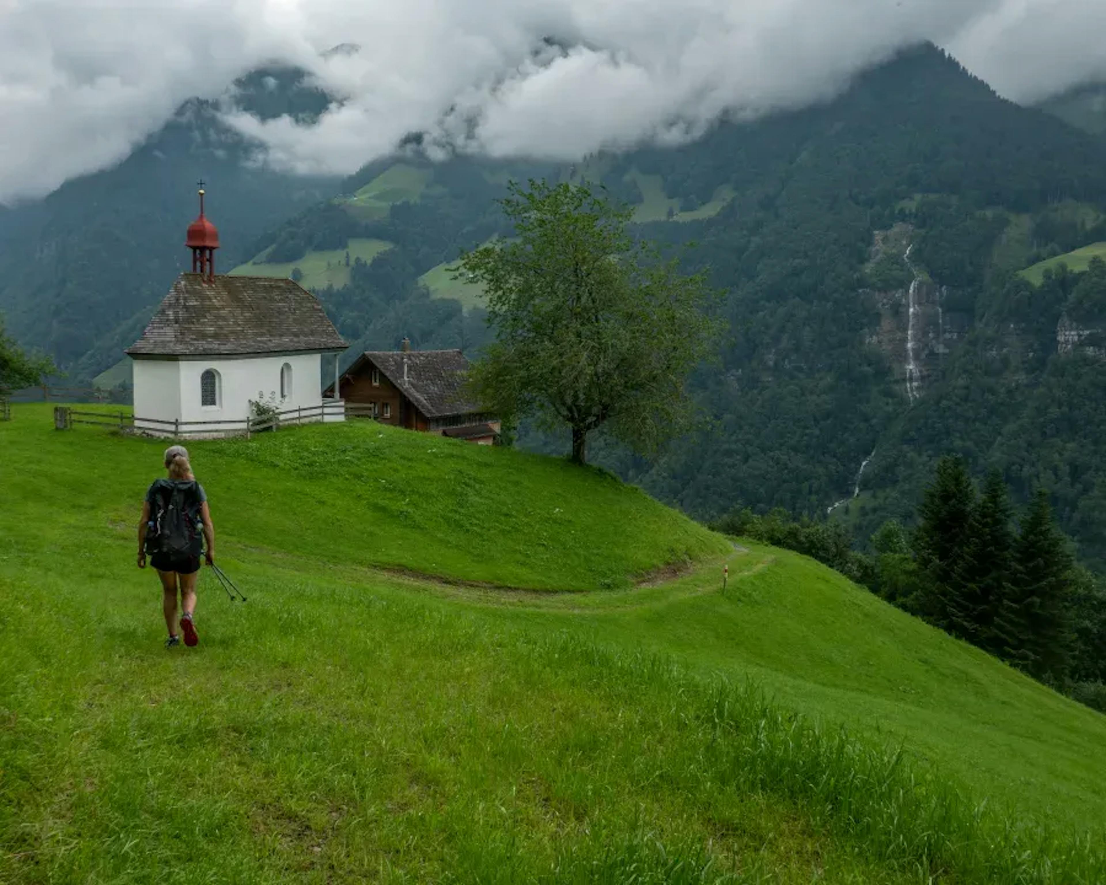 Wolfenschiessen Wellenberg, Wanderer auf Alpenwiese, Kapelle und Berglandschaft.