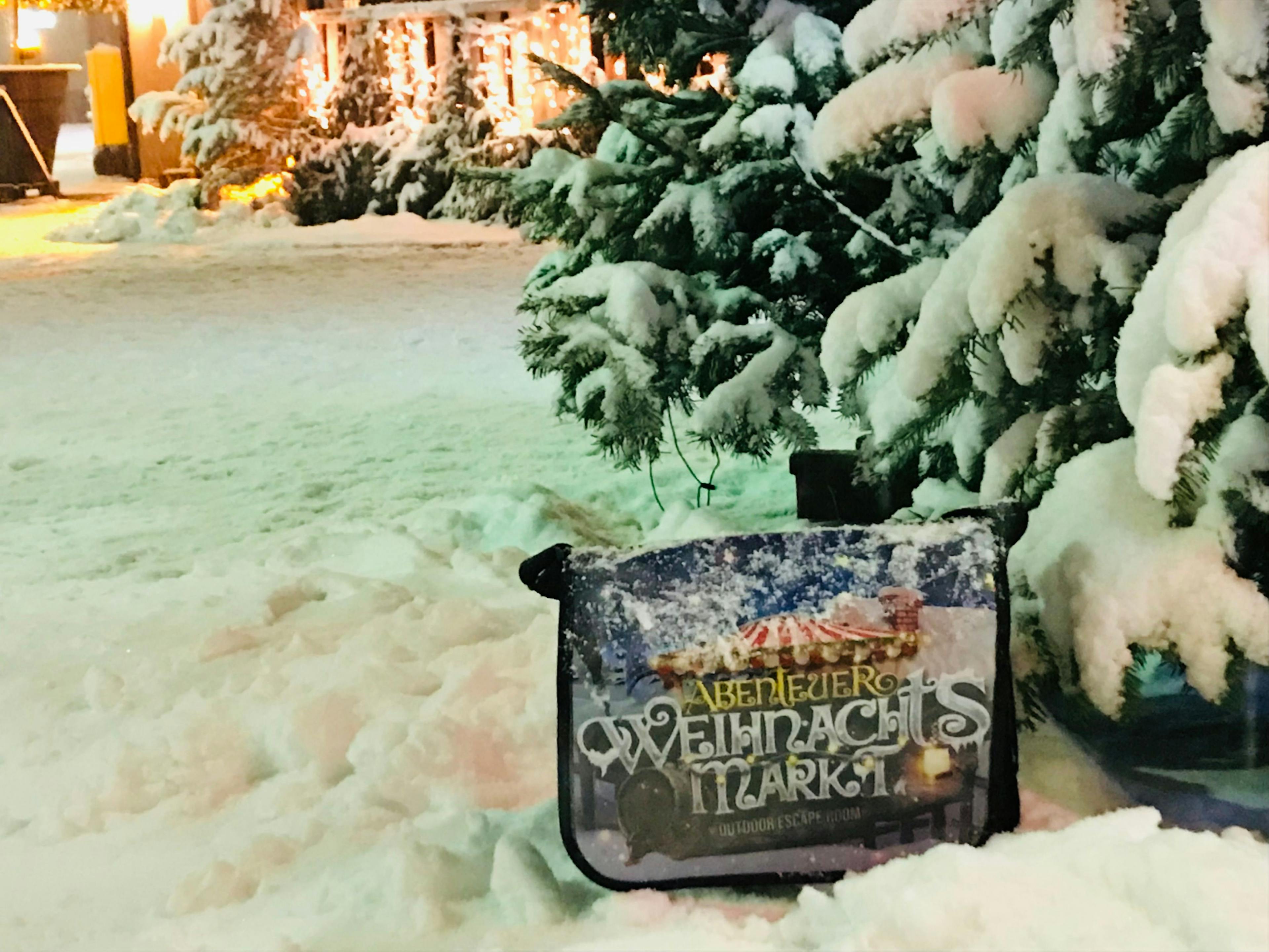 Weihnachtsmarkt: Schneebedeckter Boden und festliche Stimmung mit Lichtern und Verkaufsständen.