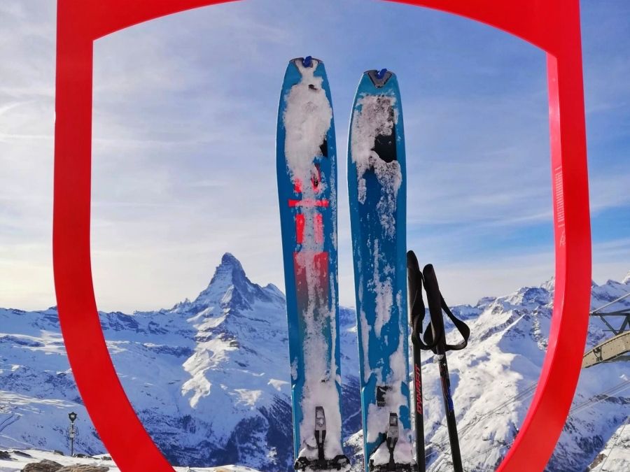 Berlibur Ski di Zermatt – Pemain ski dan tongkat di depan Matterhorn di lanskap musim dingin.