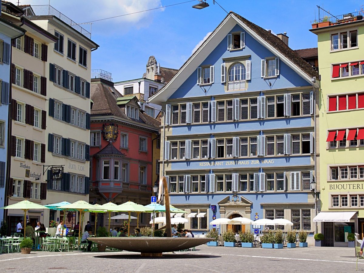 ทัวร์ eTuk ซูริกในจัตุรัสเทศบาลในสภาพอากาศฤดูใบไม้ผลิ, อาคารหลากสีในพื้นหลัง, กิจกรรมของนักท่องเที่ยว