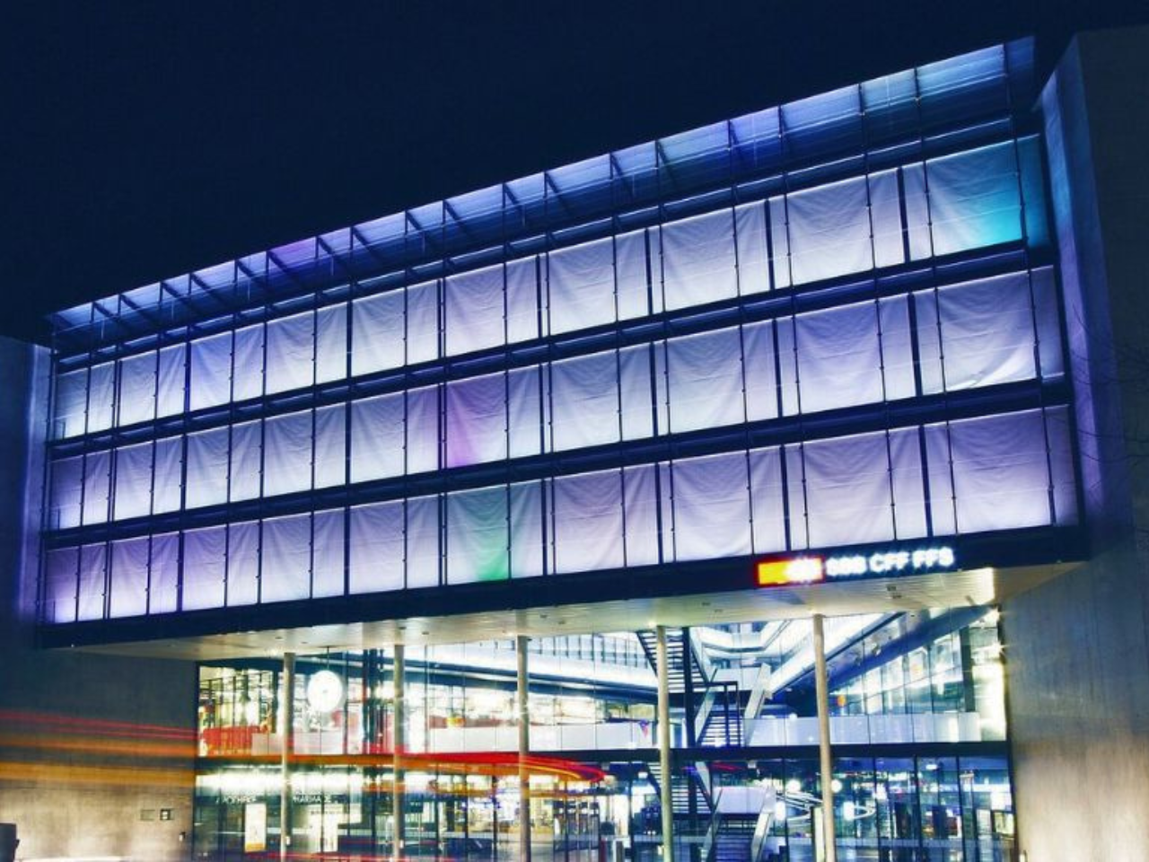 Sato Code Zug: Moderne Architektur mit lebendigem Lichtspiel in der Nacht, ideal für Fotografie und Architekturbegeisterte.