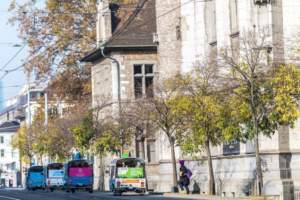 นั่งตุ๊กตุ๊กในซูริค มองถนนที่มีต้นไม้และสถาปัตยกรรม