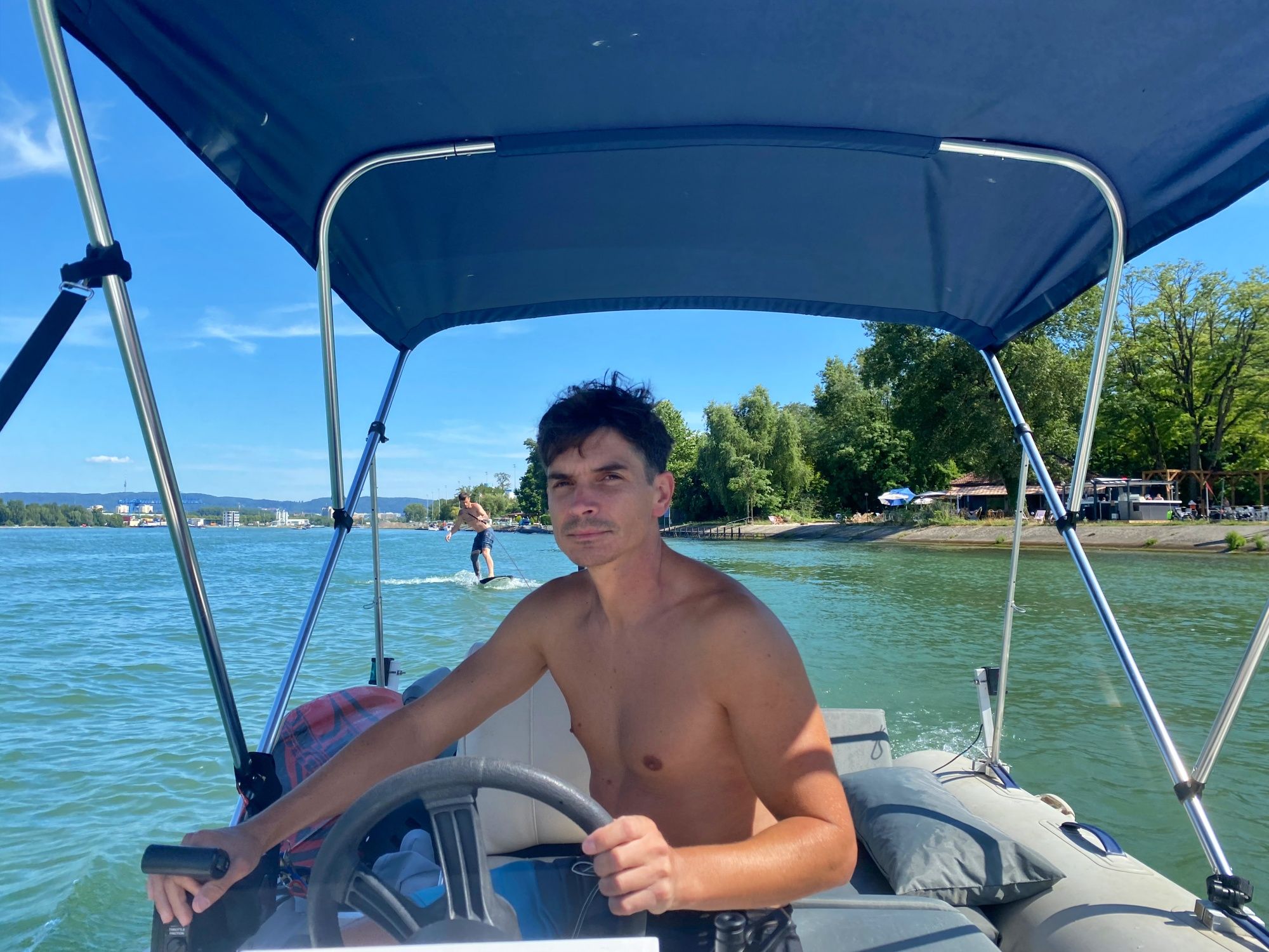 Paseo en barco por el agua con capitán y amigos bajo un brillante sol de verano.