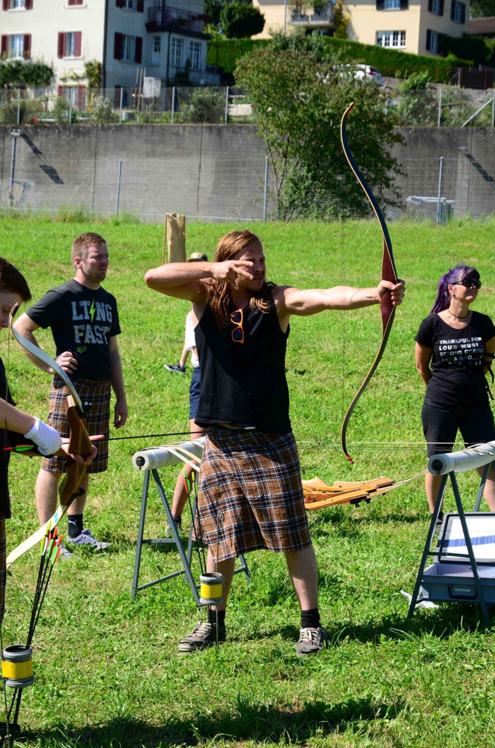 Стрельба из лука в Швейцарии, участники в килтах, луговой пейзаж, 2023