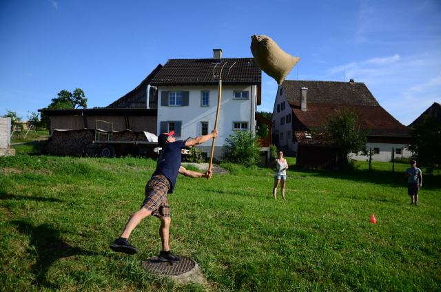 高地运动会：草地上的袋子投掷，参与者穿着运动服