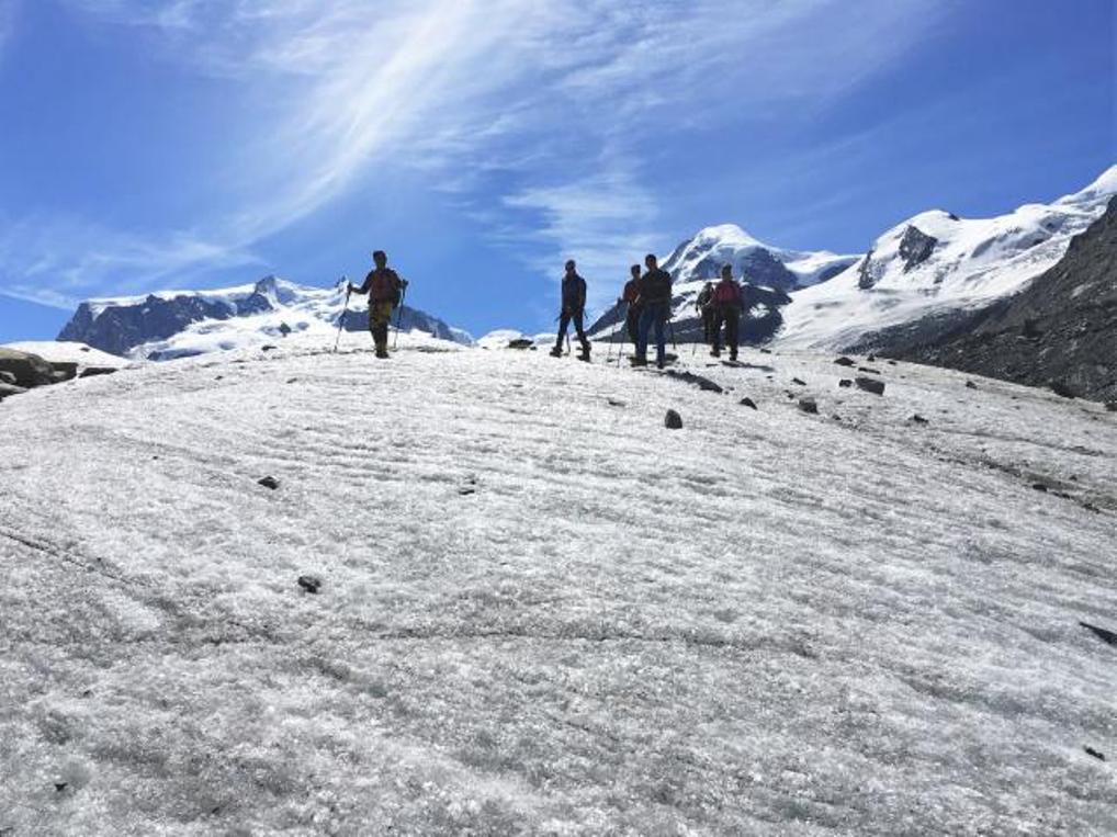 Udfordrende gletsjertur: Vandrer på gletscher i Alperne med betagende bjerglandskab om sommeren